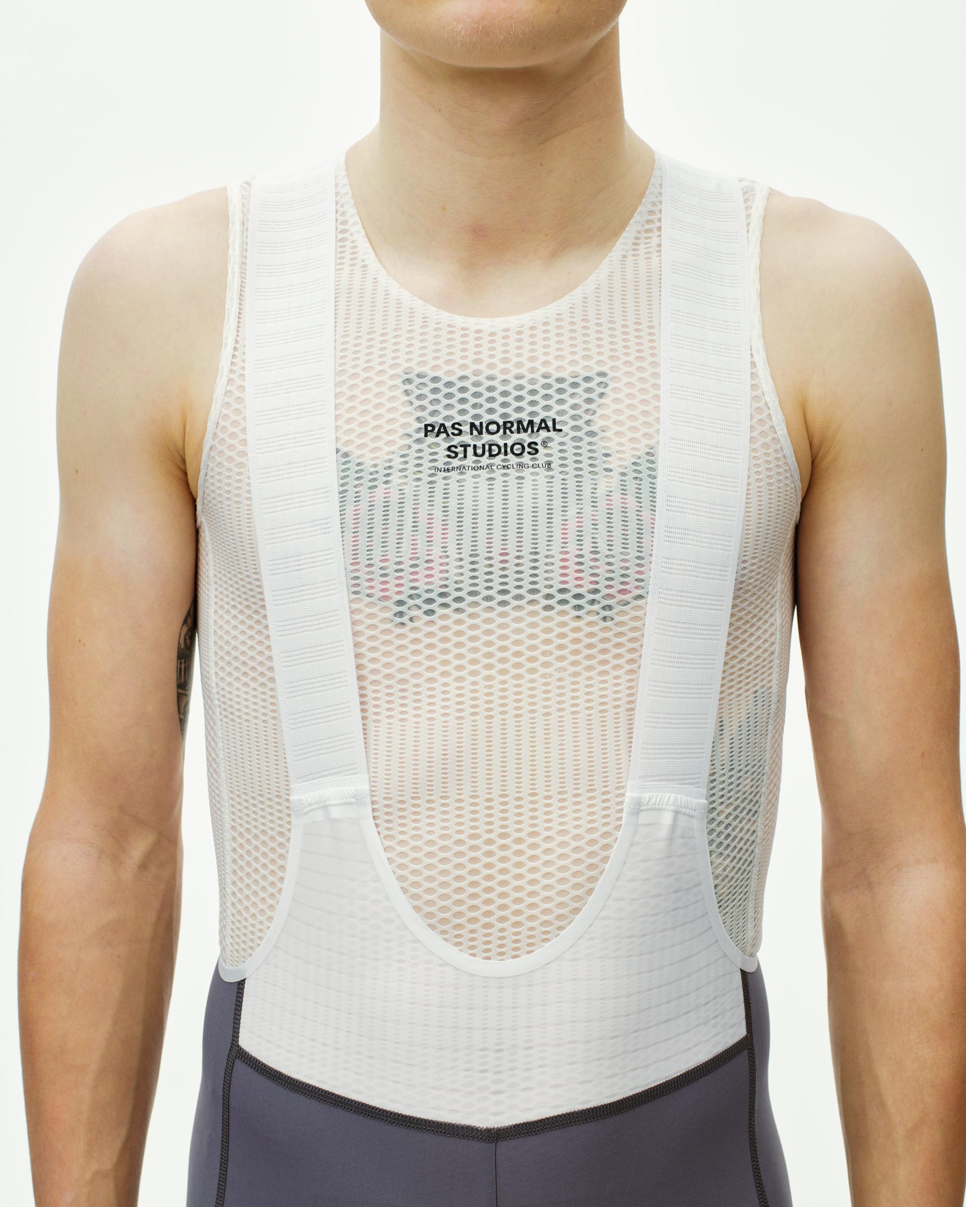 Grey men's Mechanism Pro bib straps front view, worn with white mesh sleeveless base layer