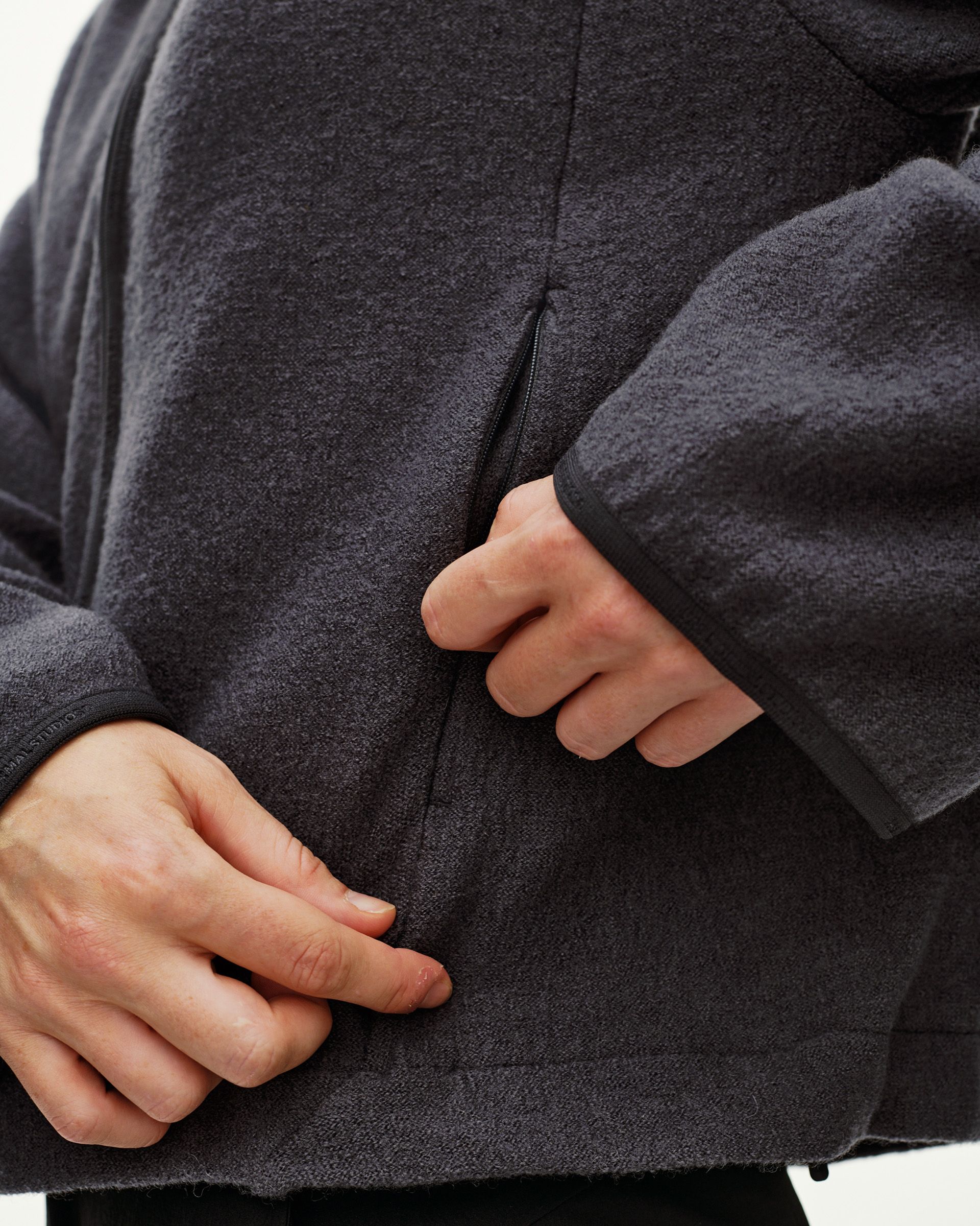 Steel grey Off-Race Boiled Wool jacket, detail view on model showing zip pocket
