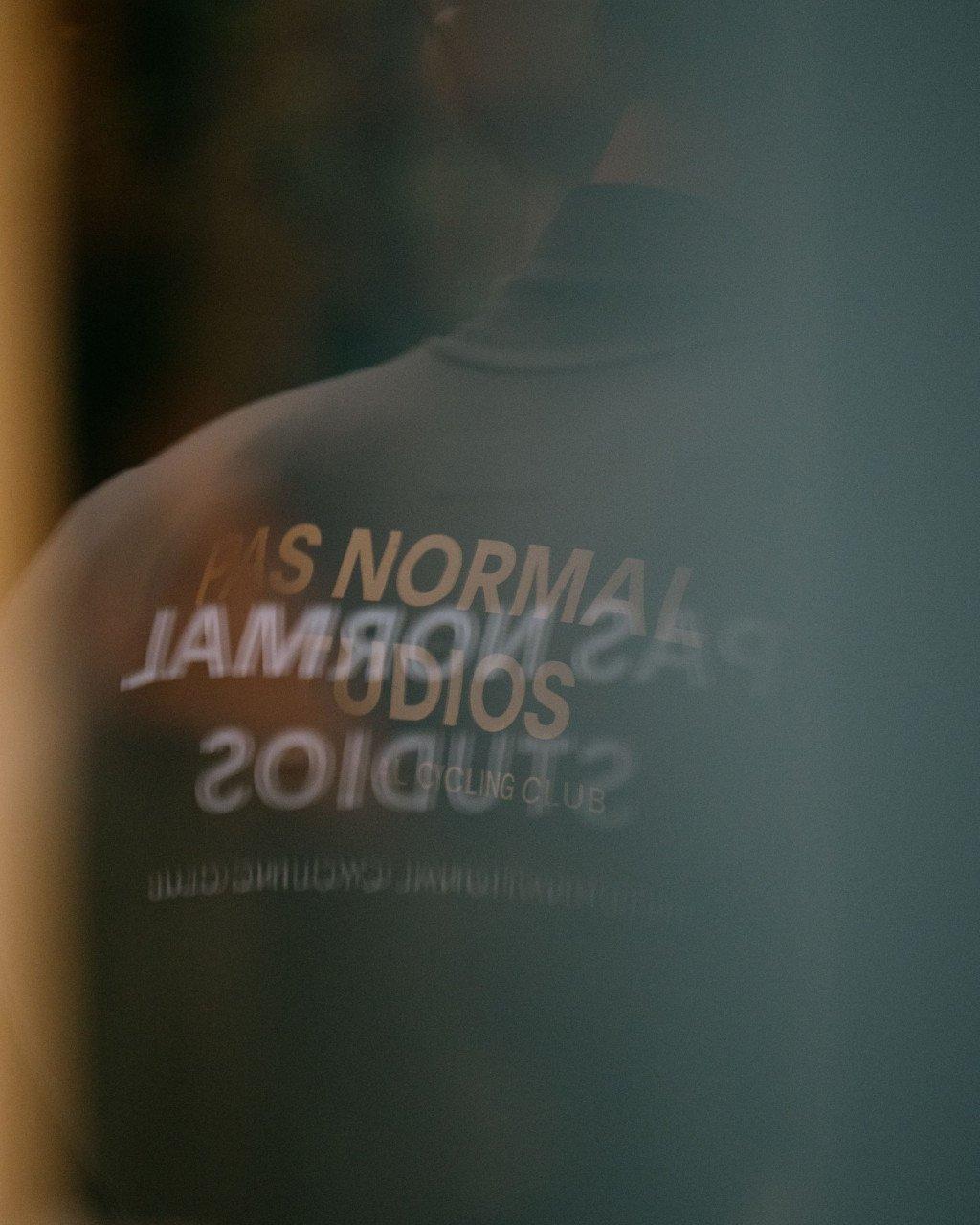 Close-up detail of grey cycling garment with white lettering and branding