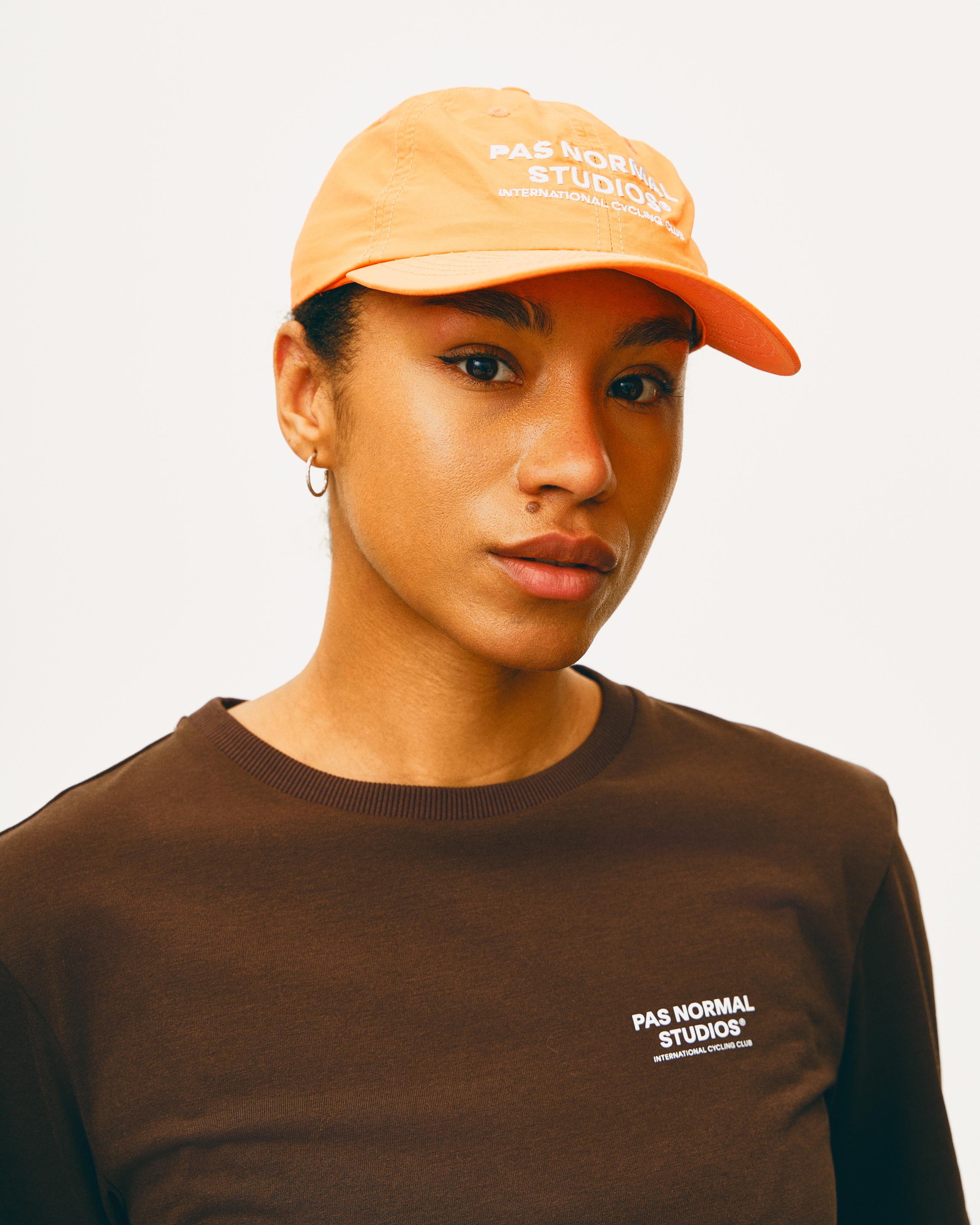 Orange Off-Race cap on model with white embroidered logo
