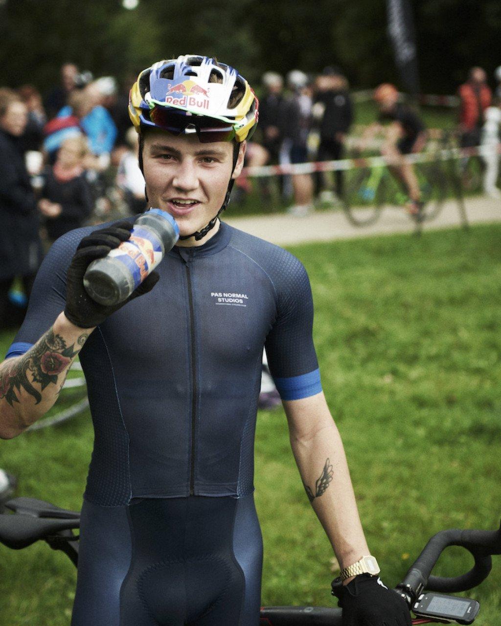 Model wearing navy cycling jersey with blue sleeve detail and chest branding during race event