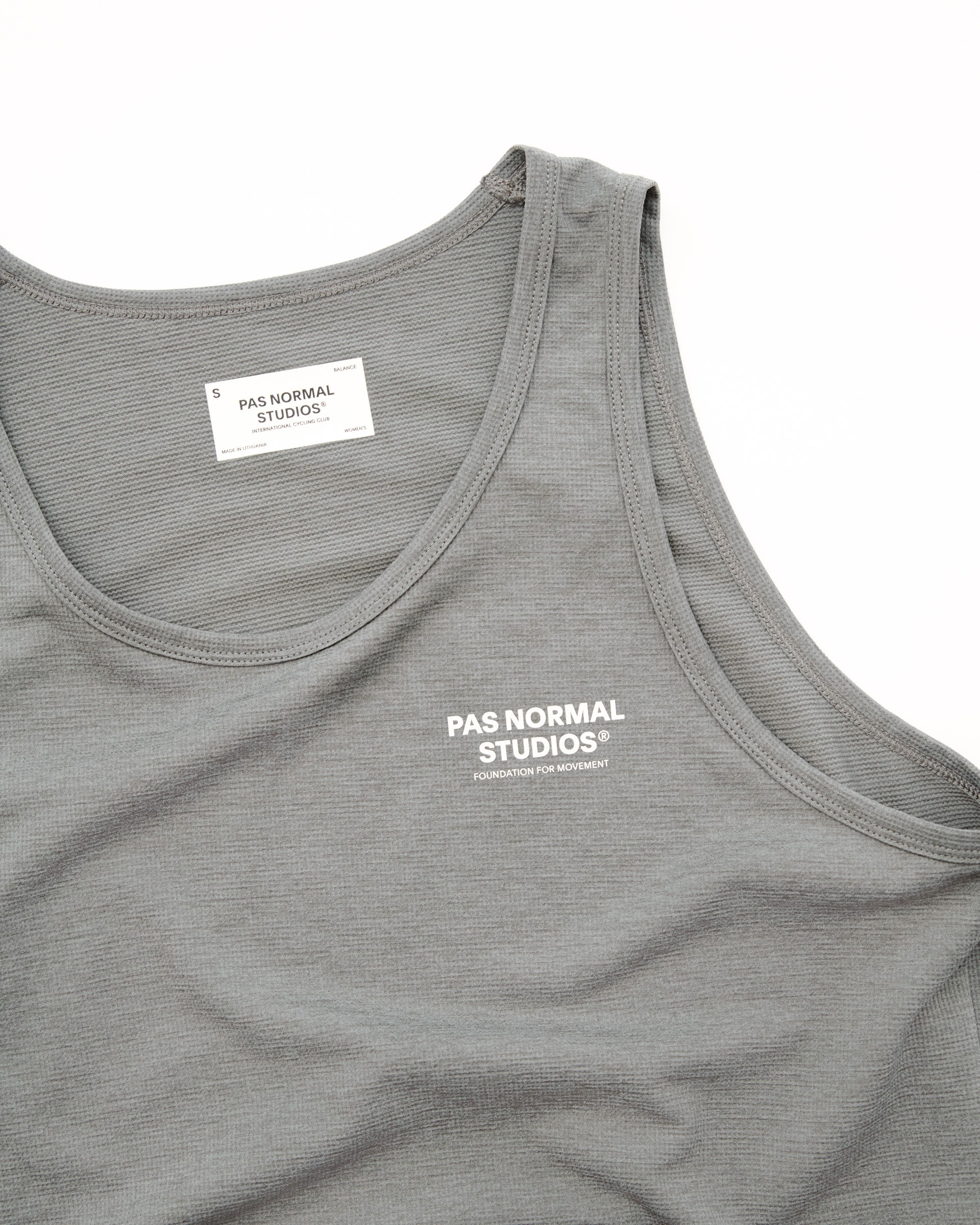 Gray merino wool tank top with logo and internal care label showing UV-protective fabric construction
