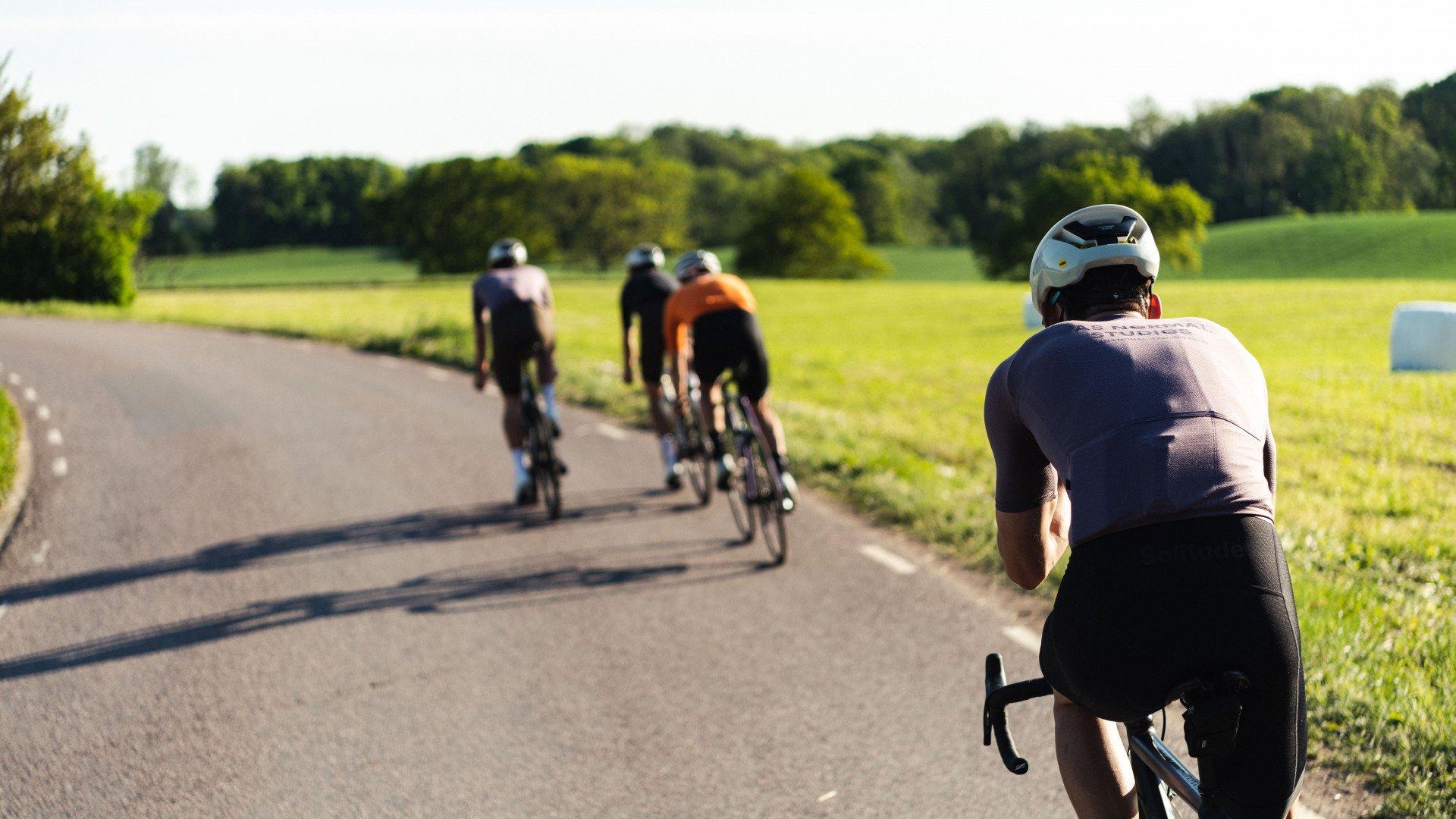Cyclists riding on country road through green countryside landscape