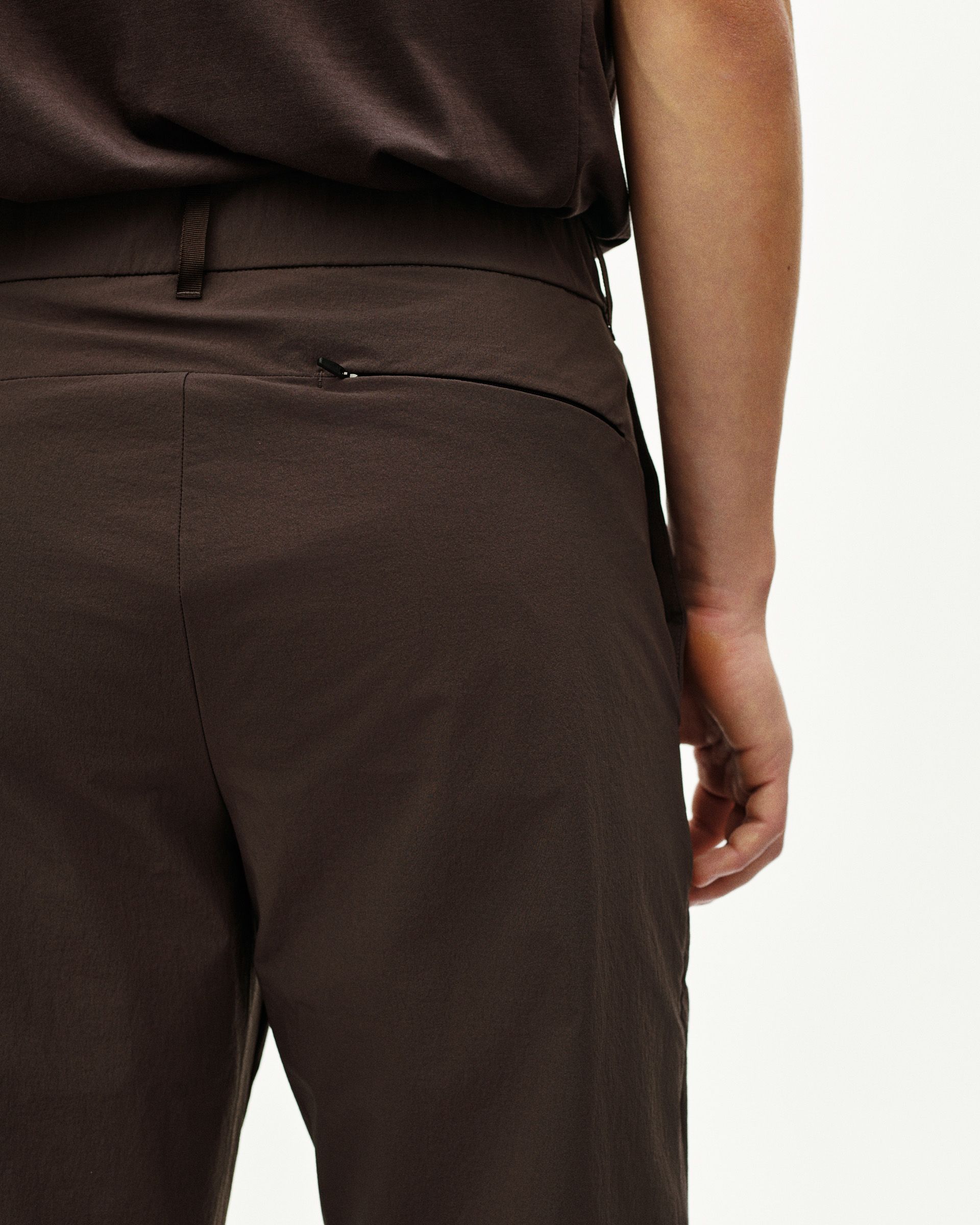 Dark Purple Off-Race Tech pants on model, rear three-quarter view with zippered pocket detail