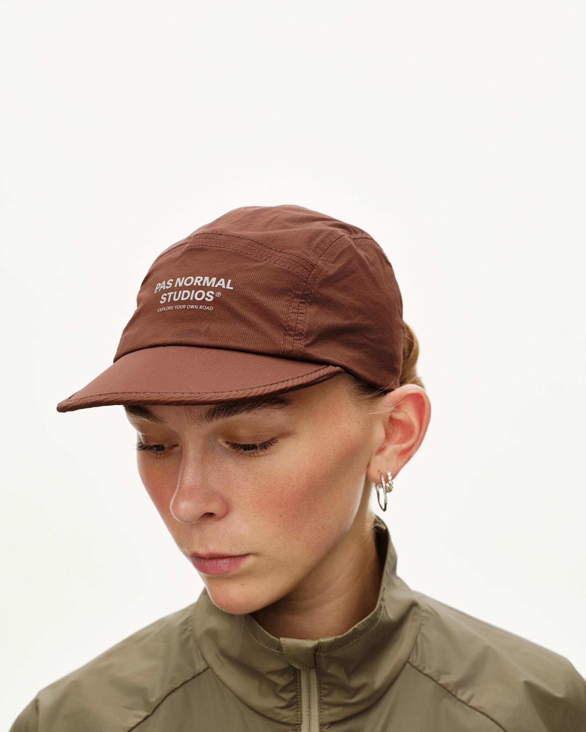 Maroon Brown Balance cap on model, front three-quarter view with white logo print on crown