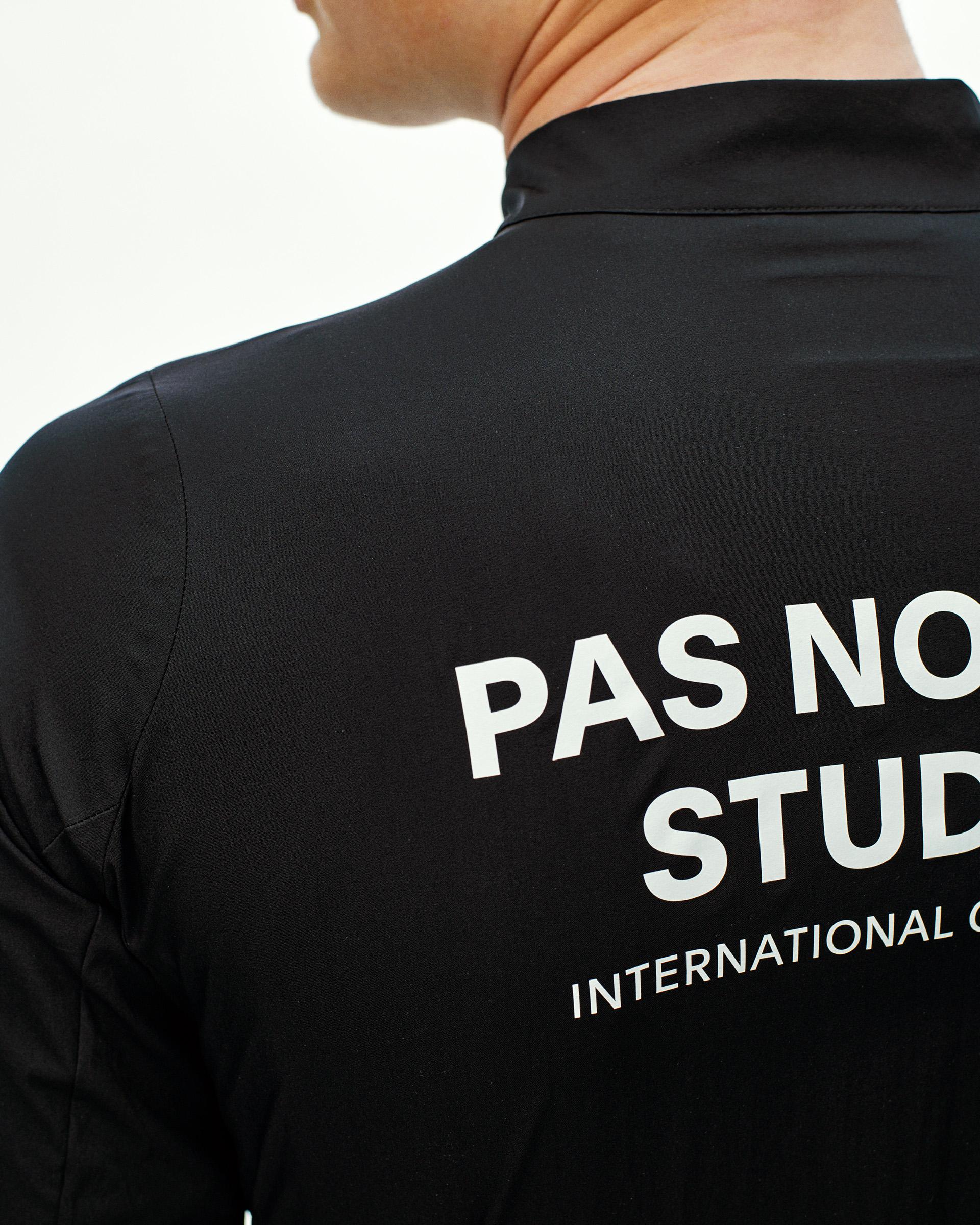 Black Mechanism Stow Away cycling jacket, rear detail on model with large white back print