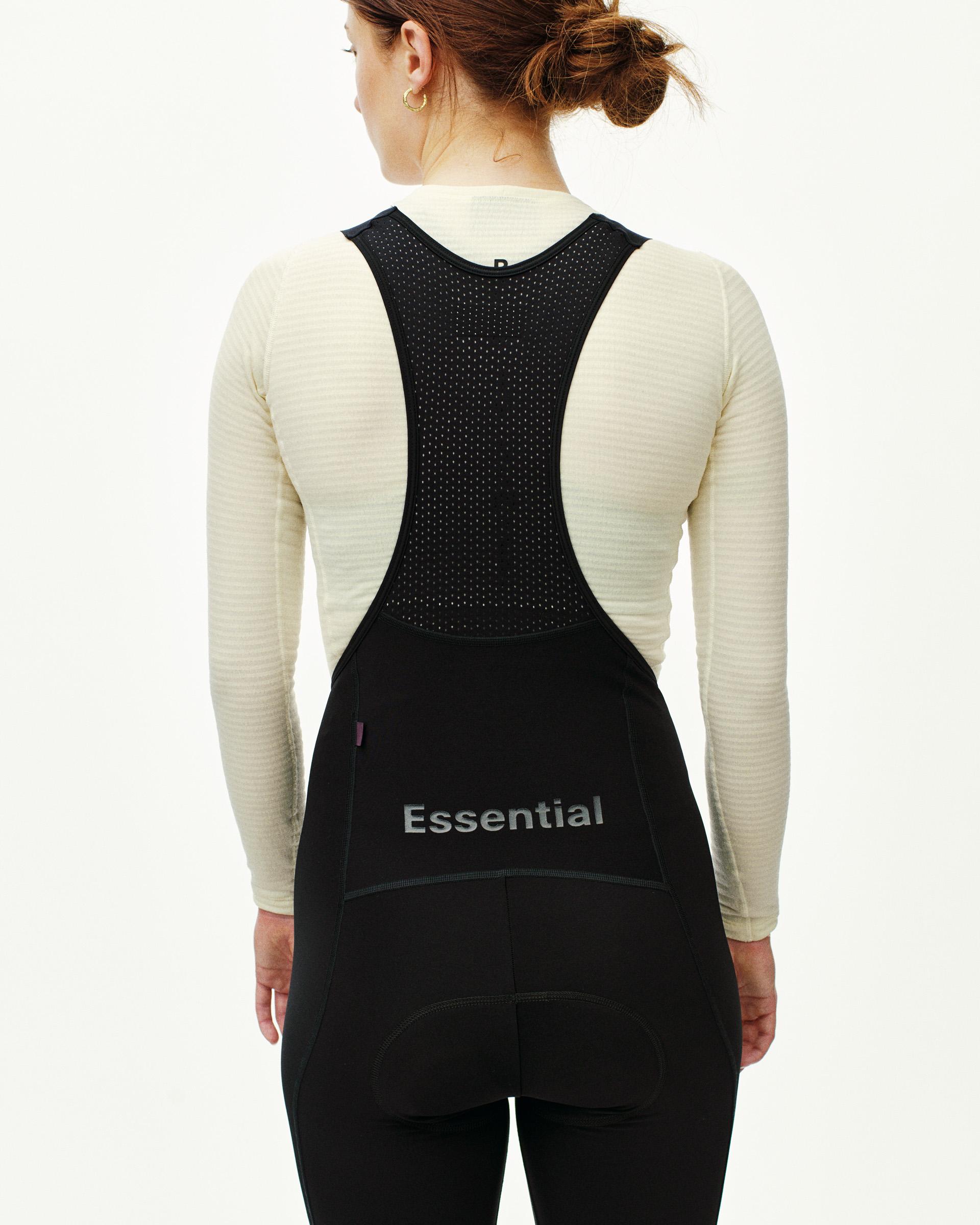 Black Essential women's thermal long cycling bibs, rear view on model with mesh bib strap panel