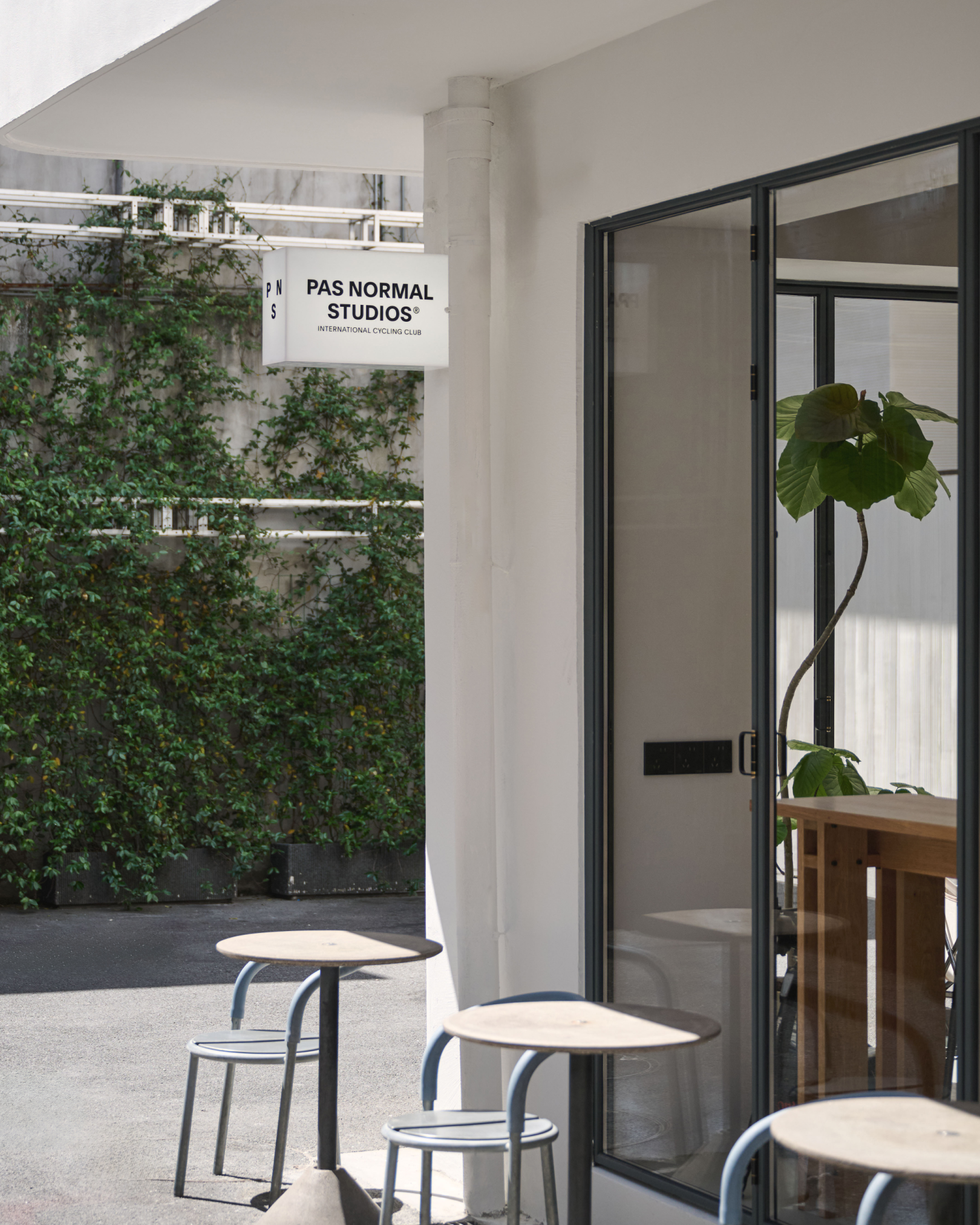 Brand storefront entrance in Shanghai with modern glass doors and outdoor seating area