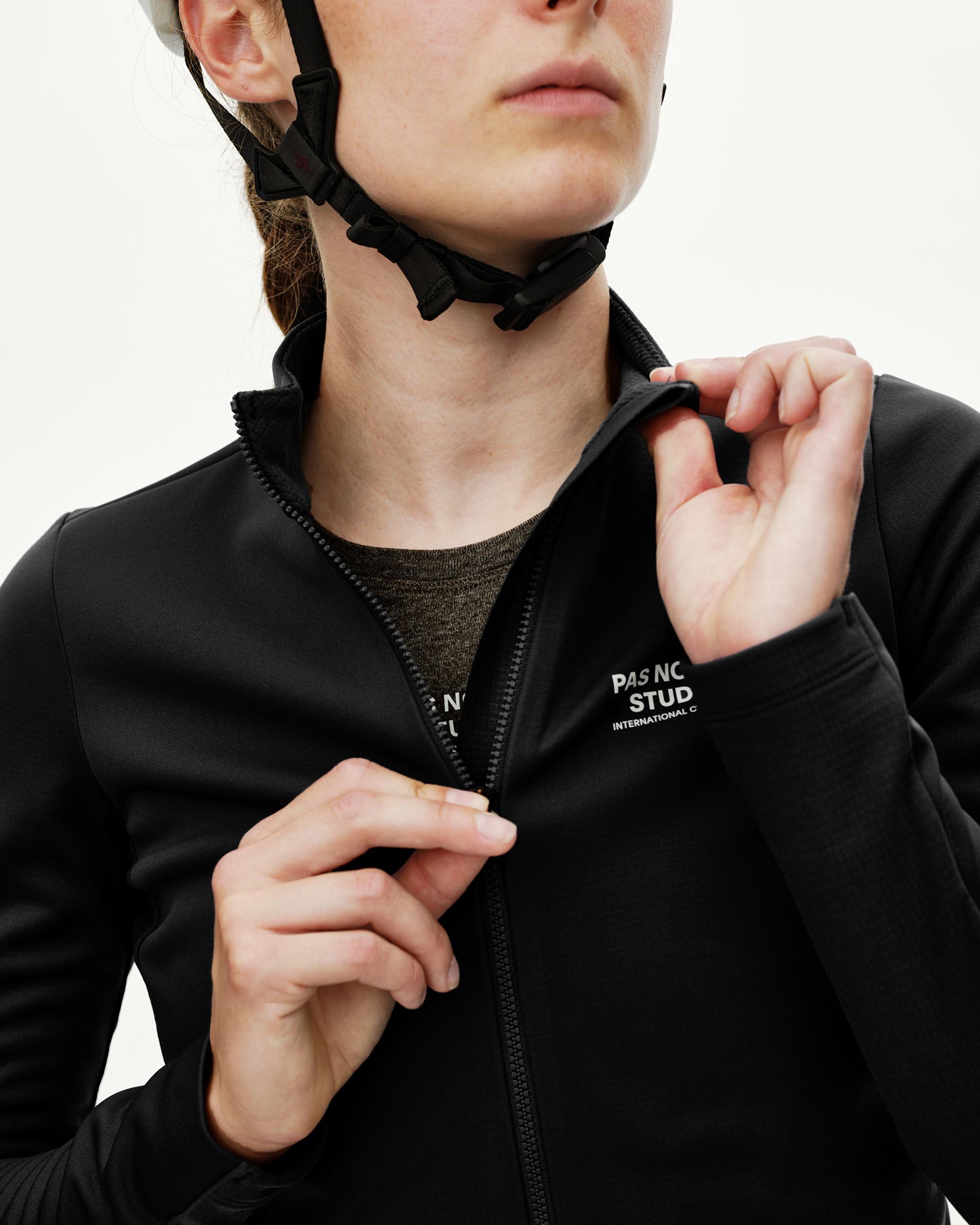 Black Mechanism thermal long sleeve cycling jersey on model, front detail view with chest text print and center zip