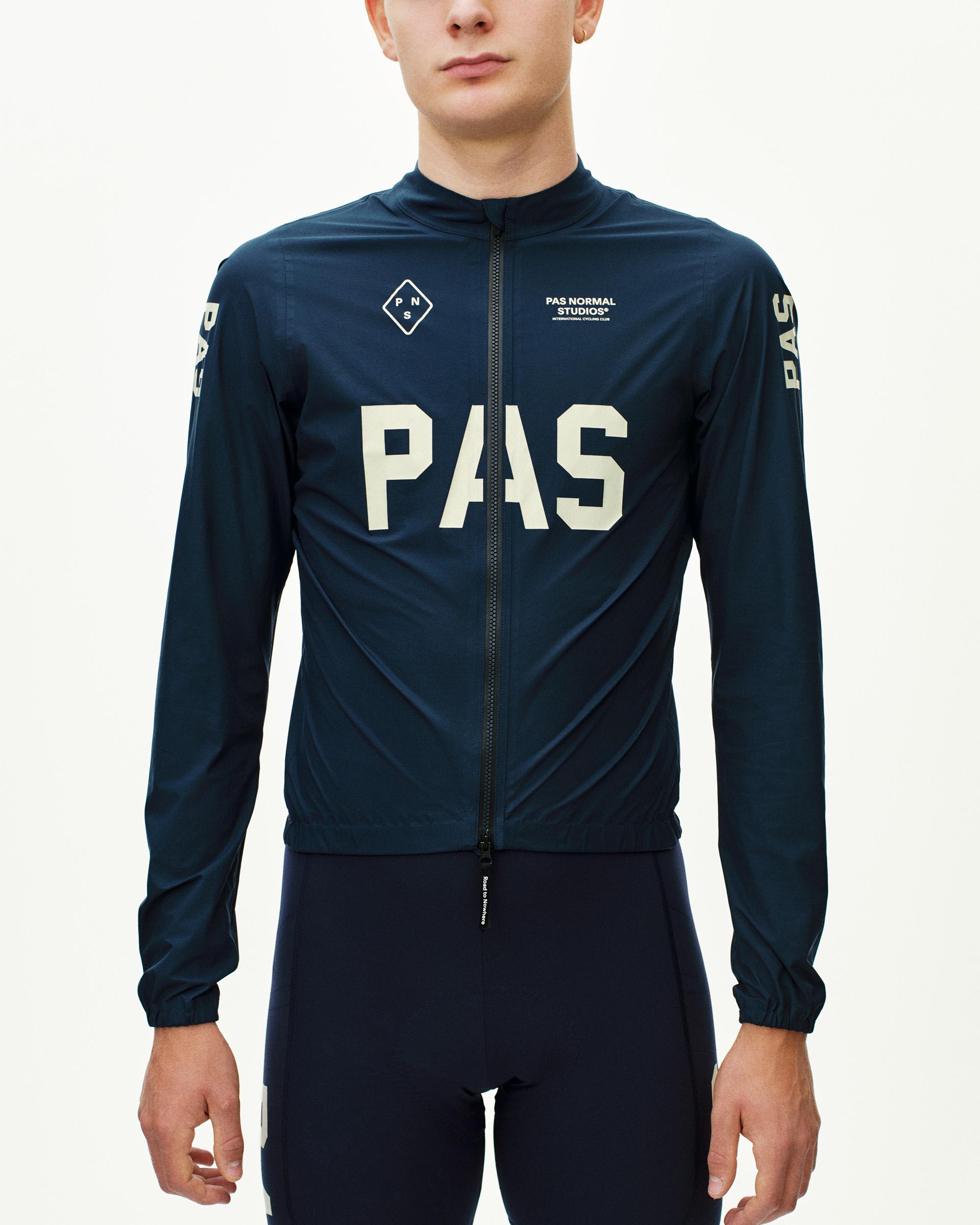 Navy PAS Mechanism Rain cycling jacket on model with large white chest logo