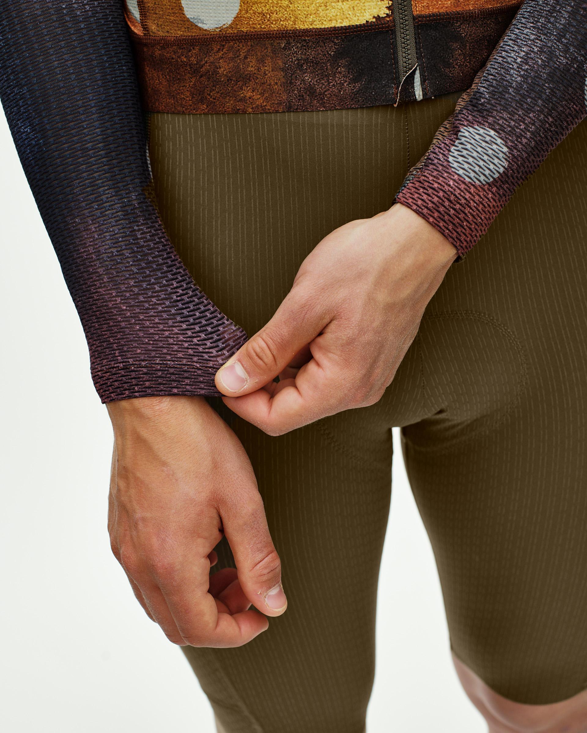 Brown T.K.O. Essential Light long sleeve cycling jersey on model with striped sleeves and earth tone print