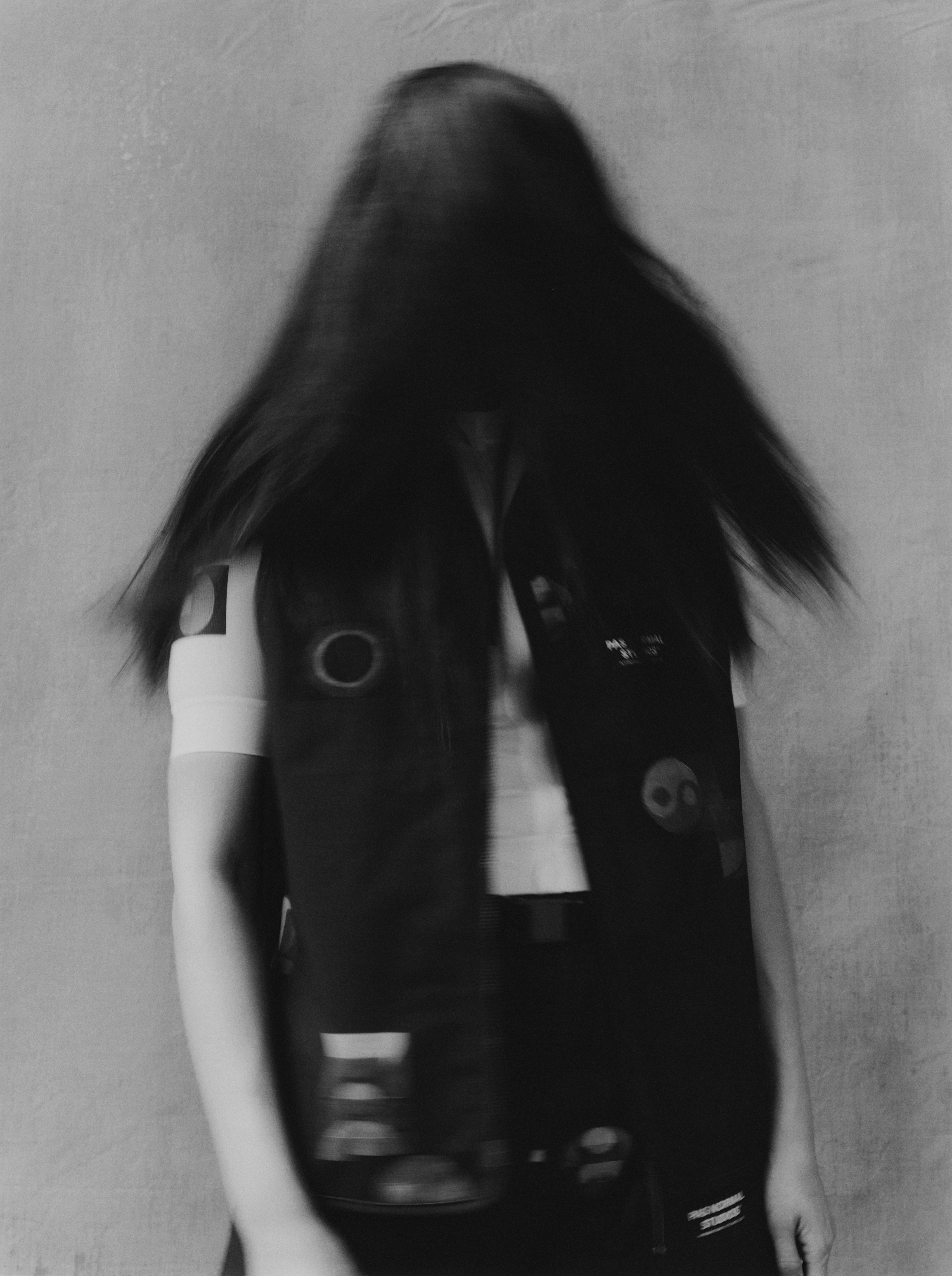 Model wearing black T.K.O. cycling jersey with geometric pattern details, artistic black and white photography