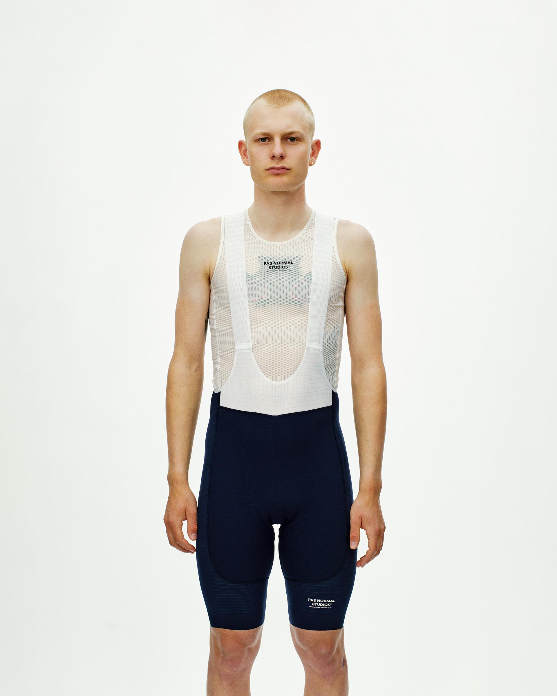 Navy Mechanism Pro men's cycling bibs, front view on model with mesh bib straps