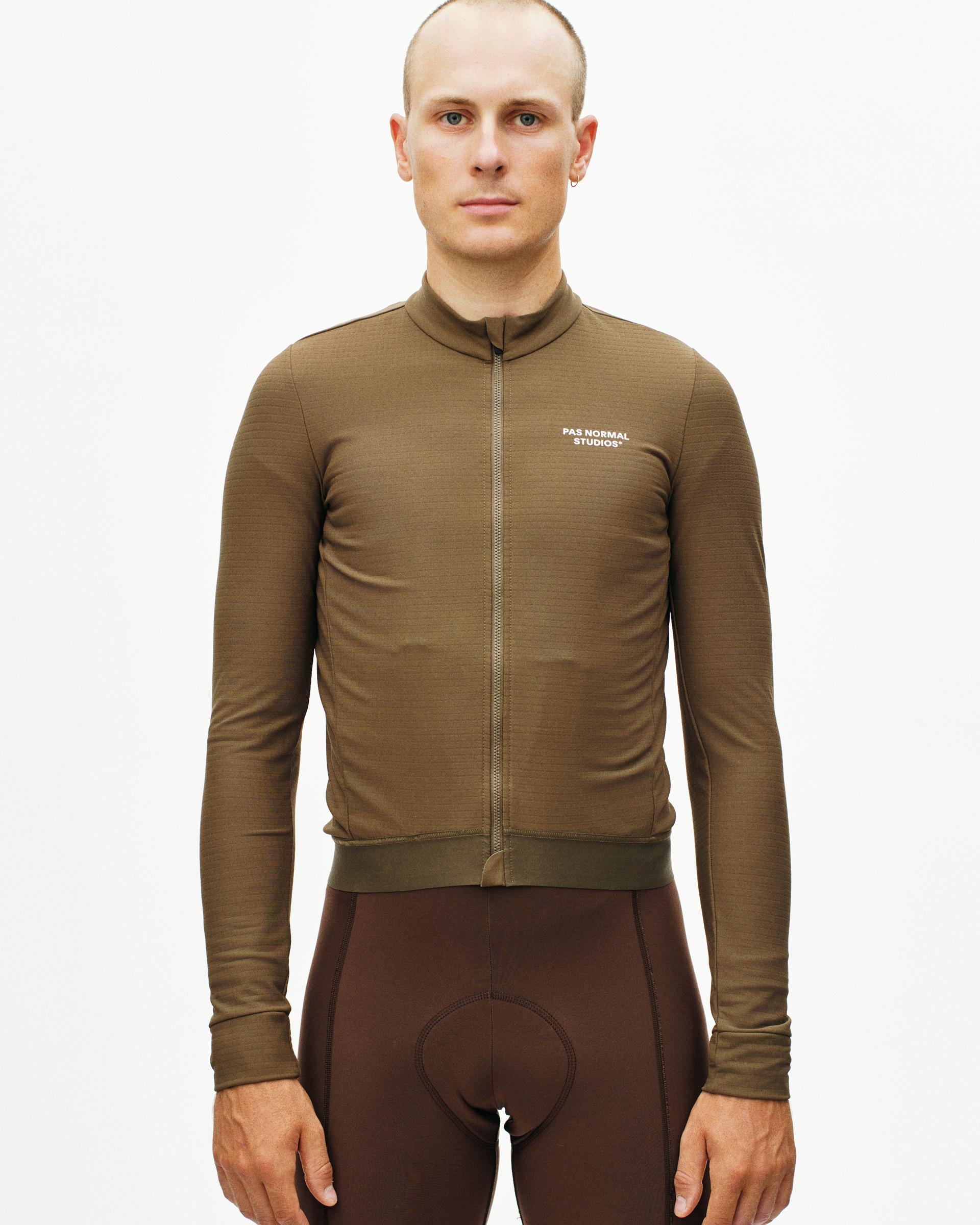 Brown Essential long sleeve cycling jersey on model with white chest logo