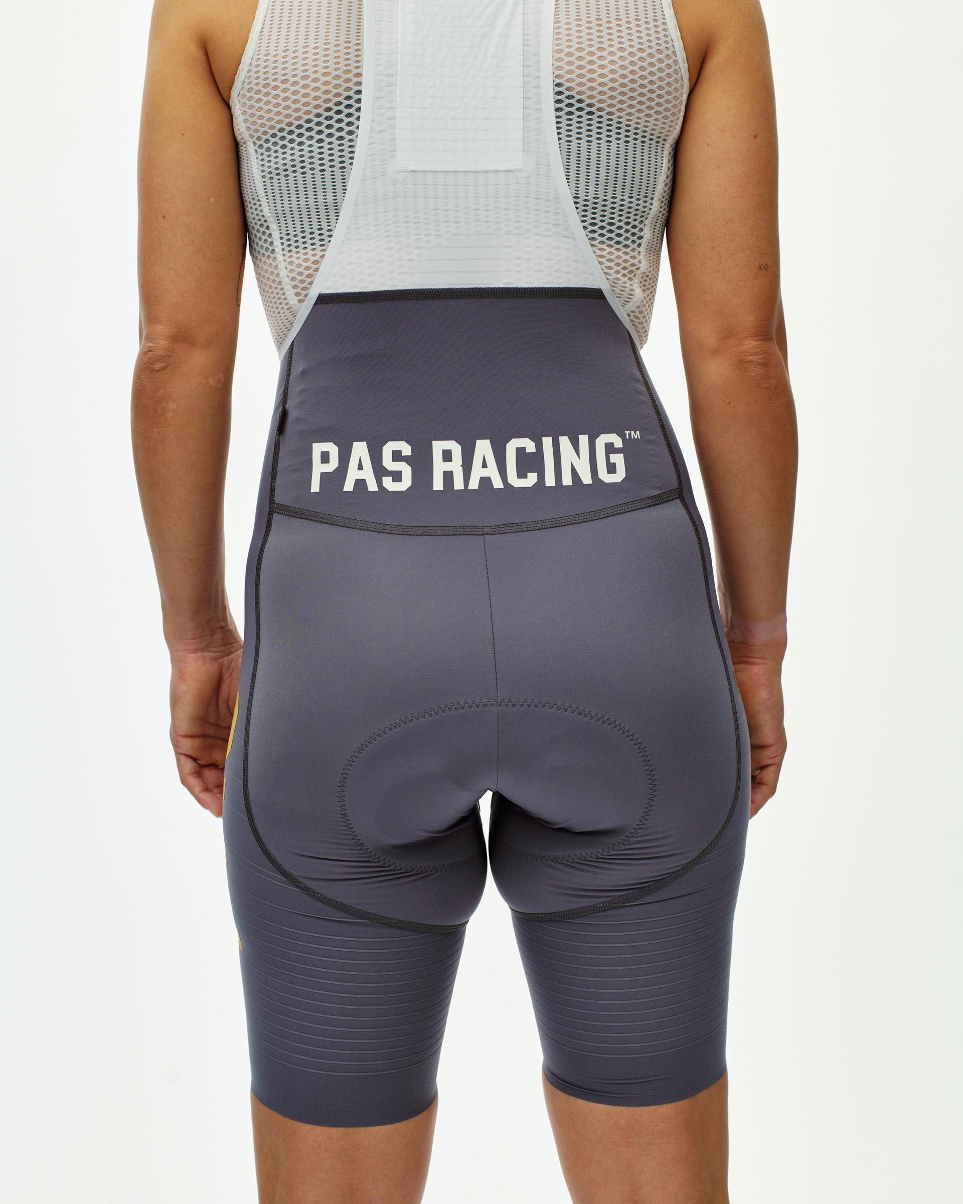 Grey Mechanism Pro PAS Racing women's cycling bibs on model, rear view with PAS Racing waistband print