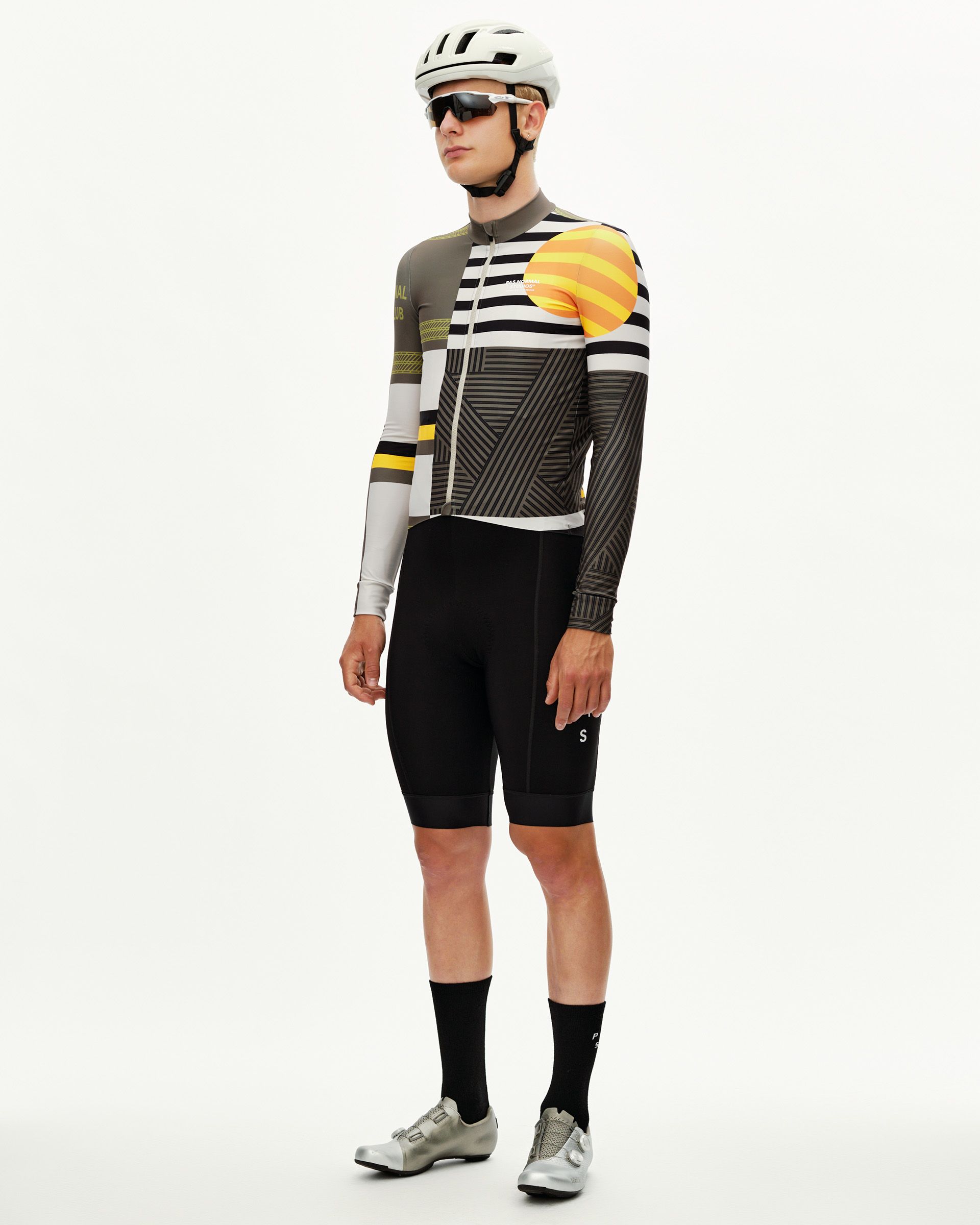 Sand grey Mechanism long sleeve cycling jersey on model, three-quarter front view with bold graphic stripe and orange sun
