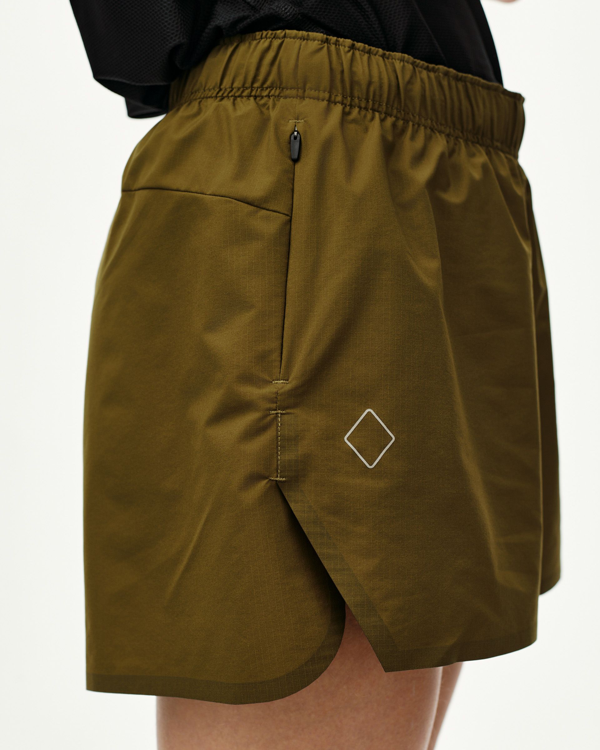 Moss Brown Balance women's shorts, side view on model with zip pocket and diamond logo print