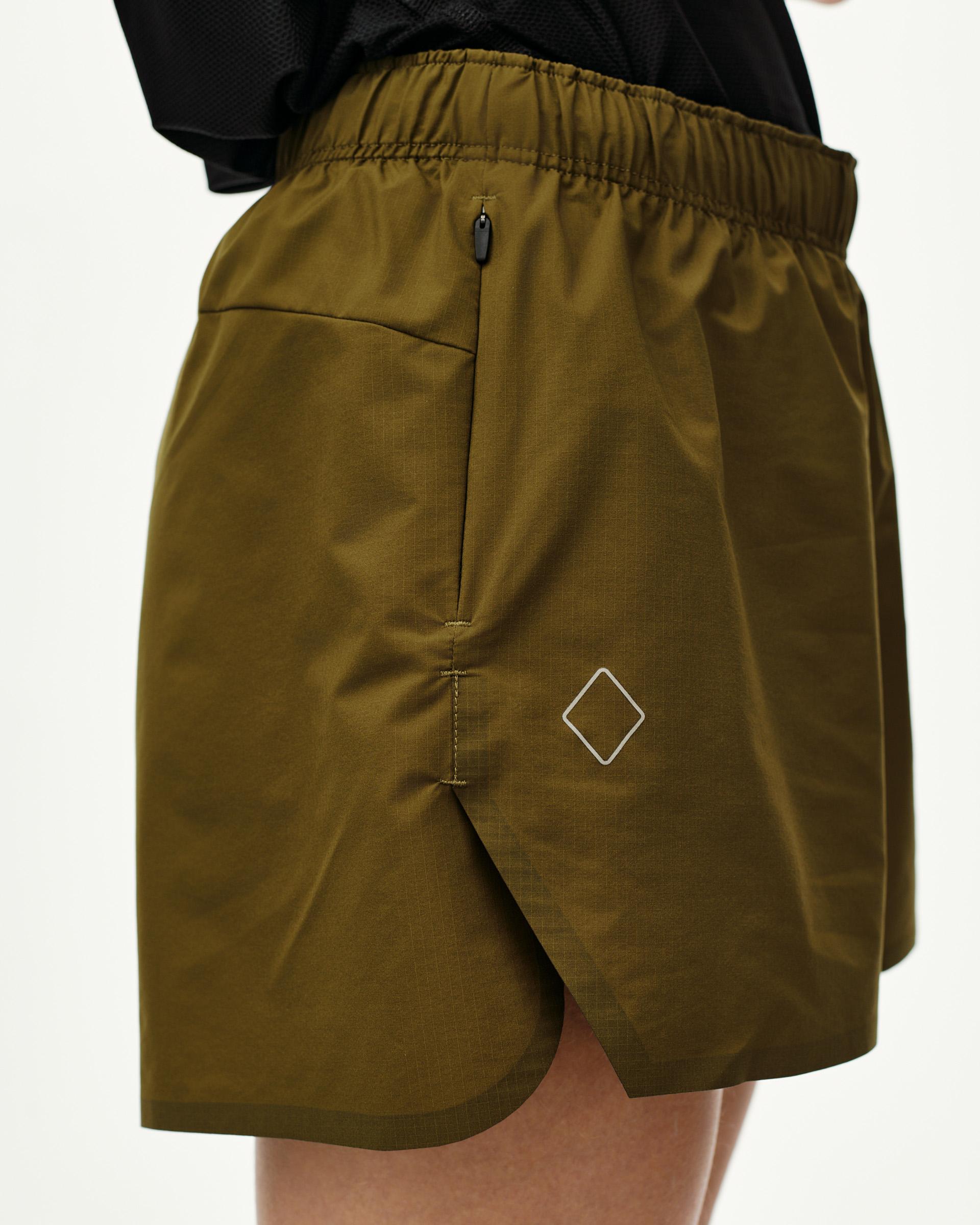 Moss Brown Balance women's shorts, side view on model with zip pocket and diamond logo print