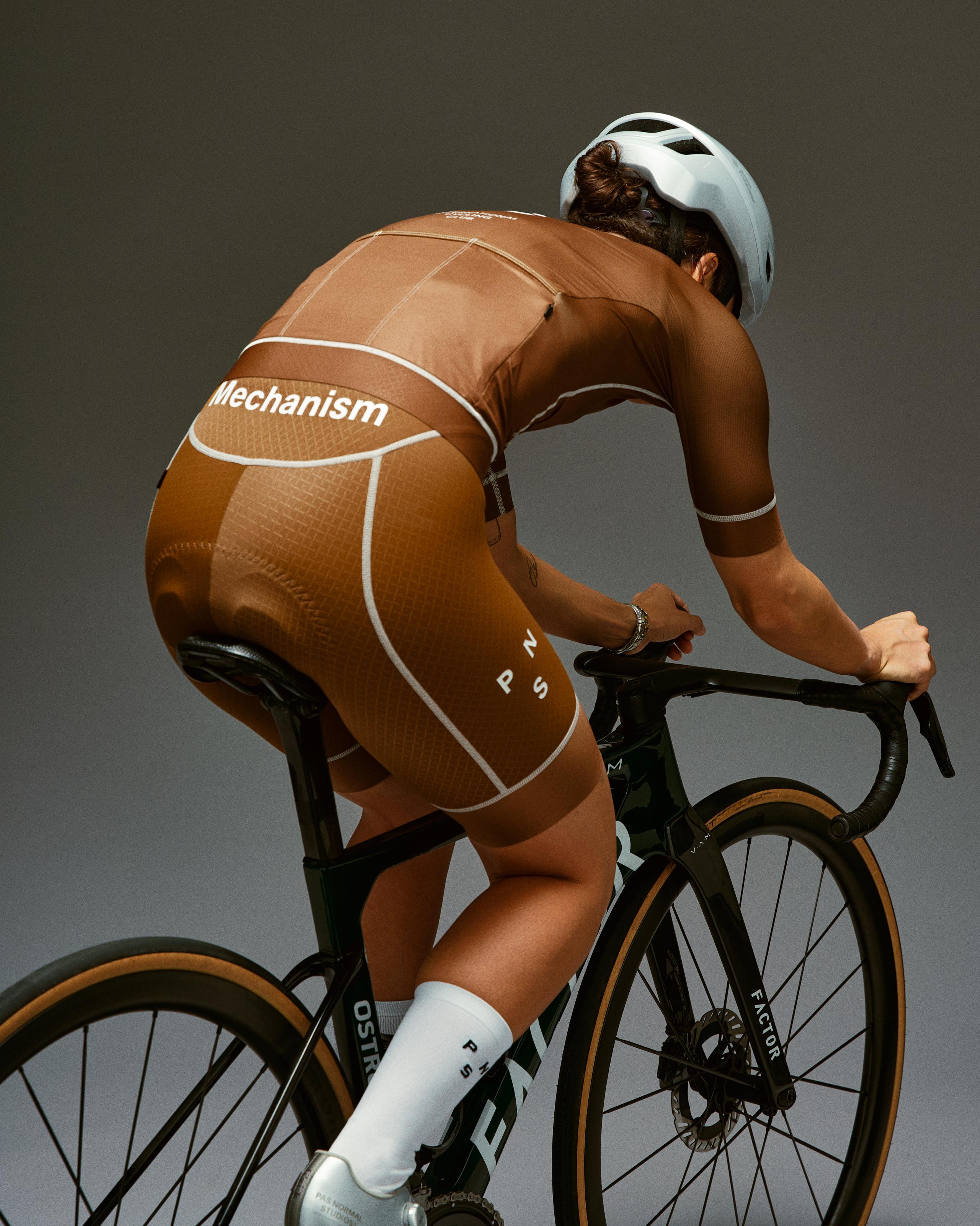 Brown Mechanism bibs on model in aerodynamic cycling position with white contrast stitching