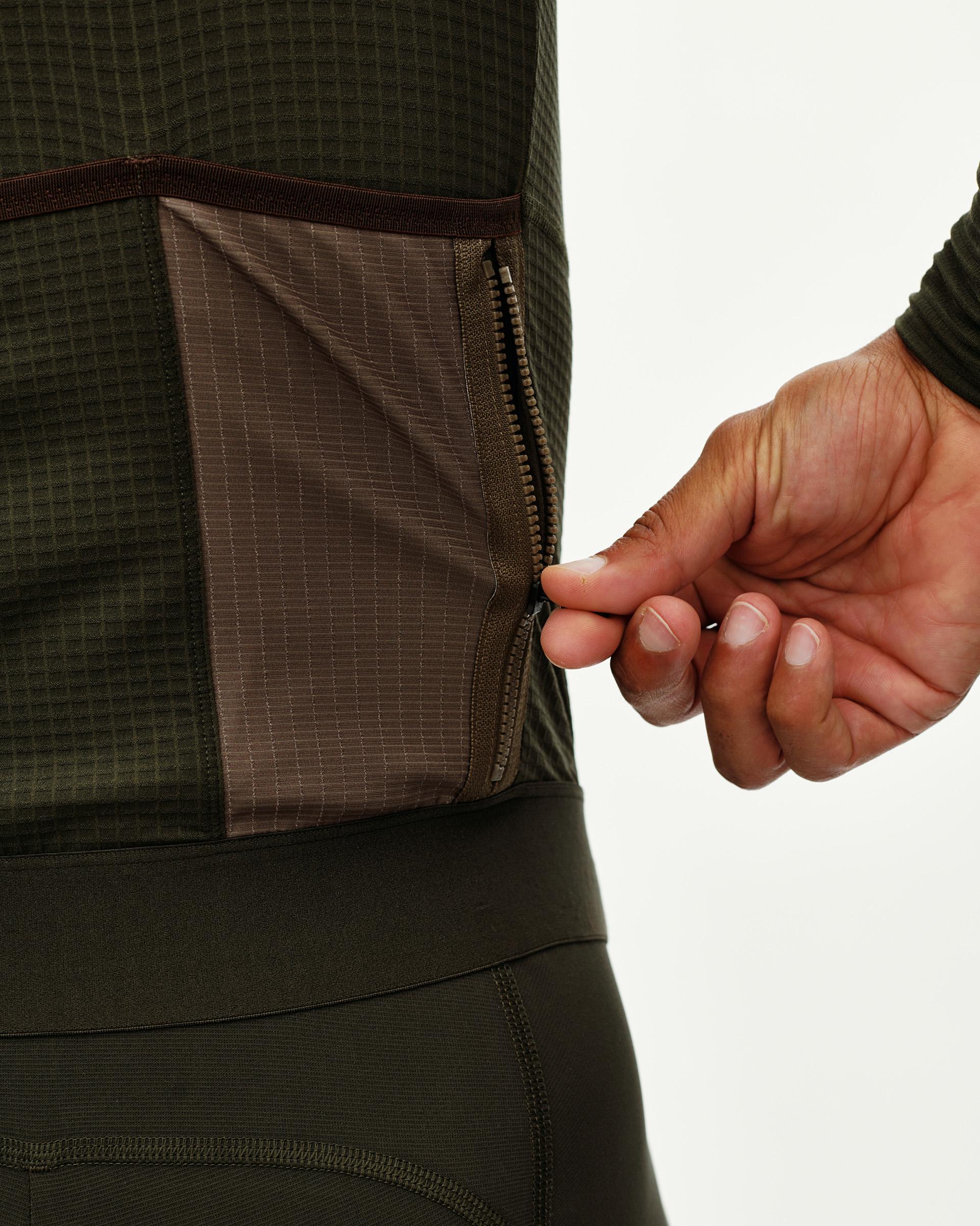 Dark Olive Escapism long sleeve cycling jersey, side detail on model showing open zip rear pocket