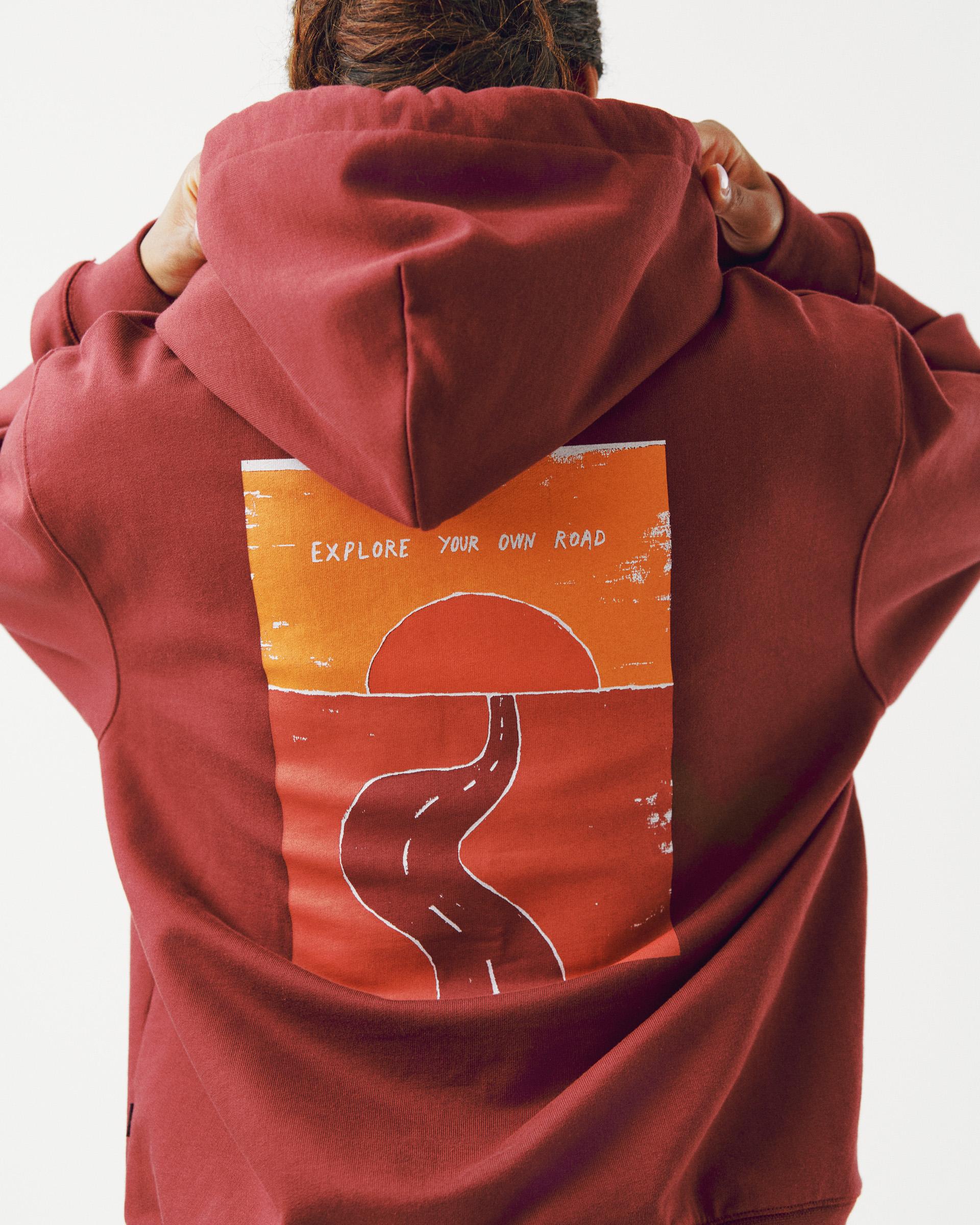 Maroon Off-Race Graphic hoodie on model, rear view with orange road graphic and "Explore Your Own Road" text