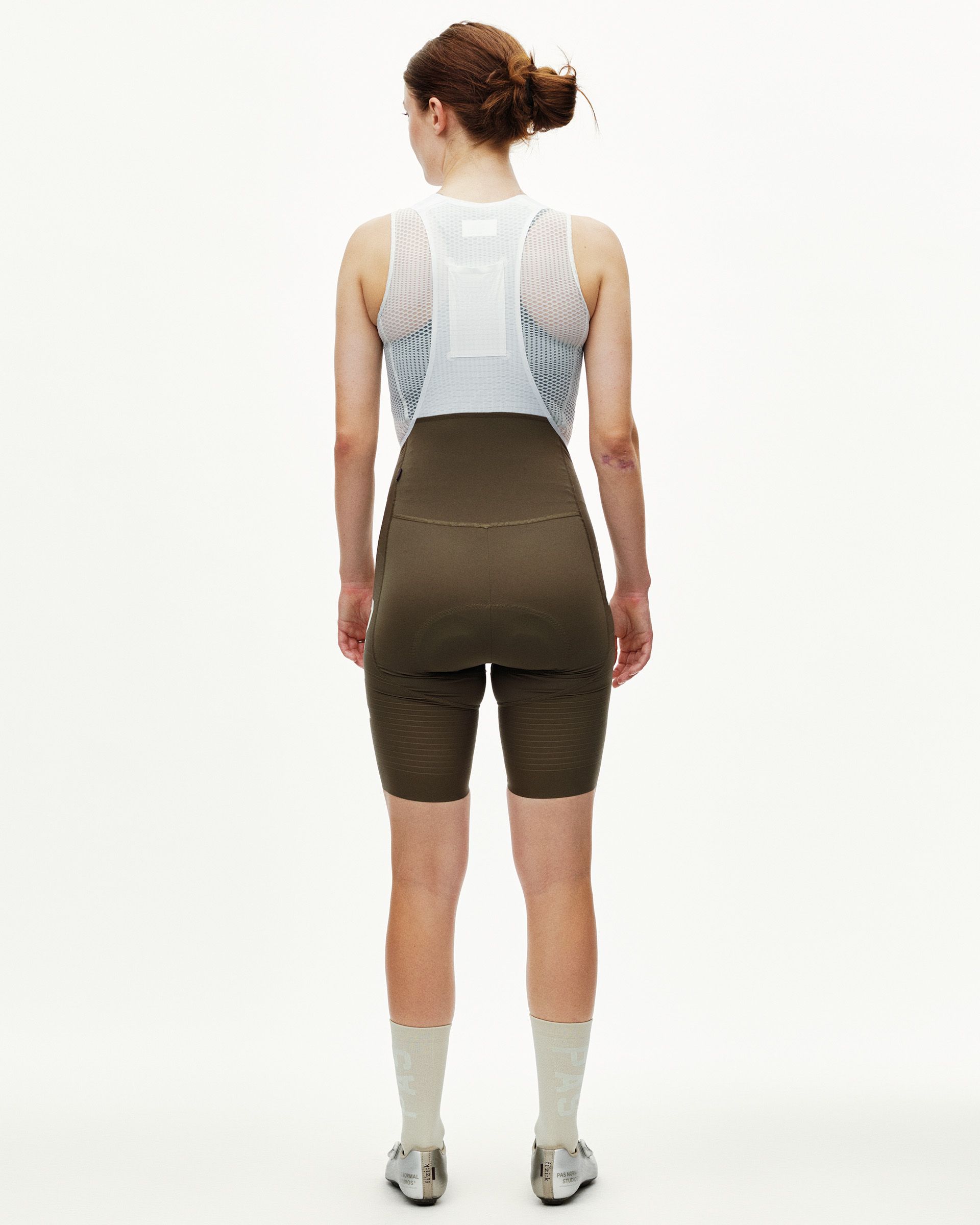 Dark Earth brown PAS Mechanism Pro women's cycling bibs on model, rear view with mesh bib straps