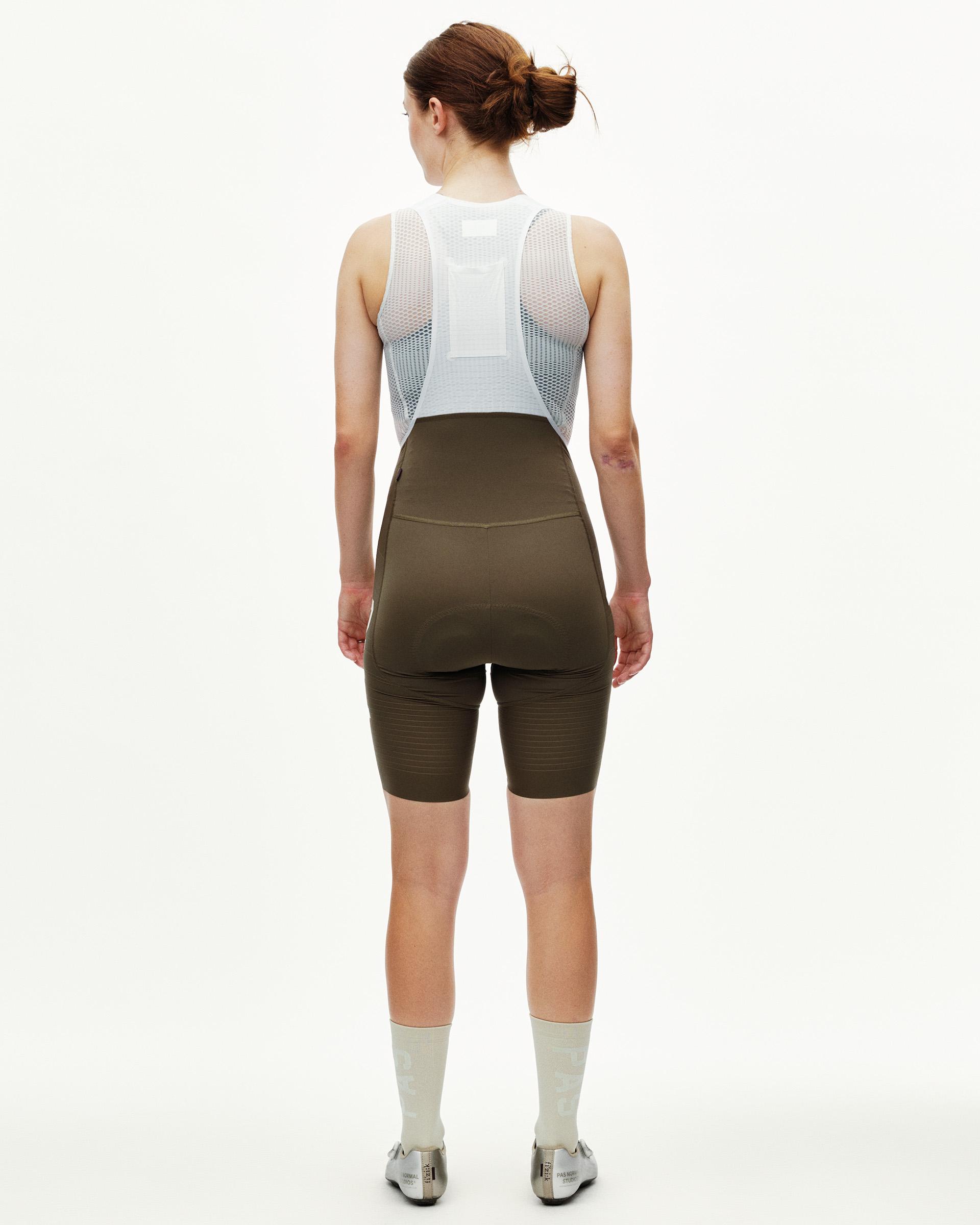 Dark Earth brown PAS Mechanism Pro women's cycling bibs on model, rear view with mesh bib straps