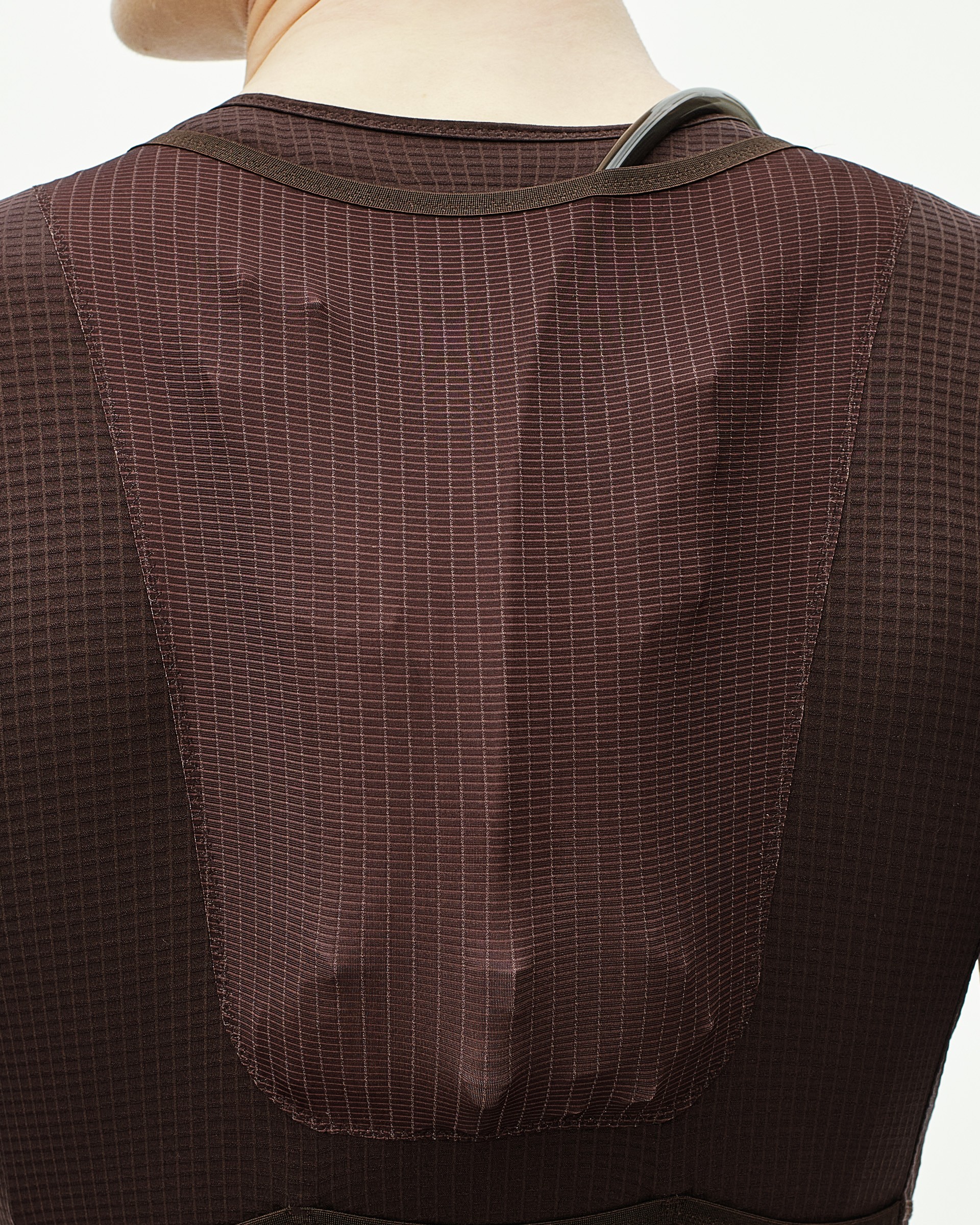 Back panel of cycling speedsuit with reinforced shoulder straps and rear pocket for hydration bladder storage
