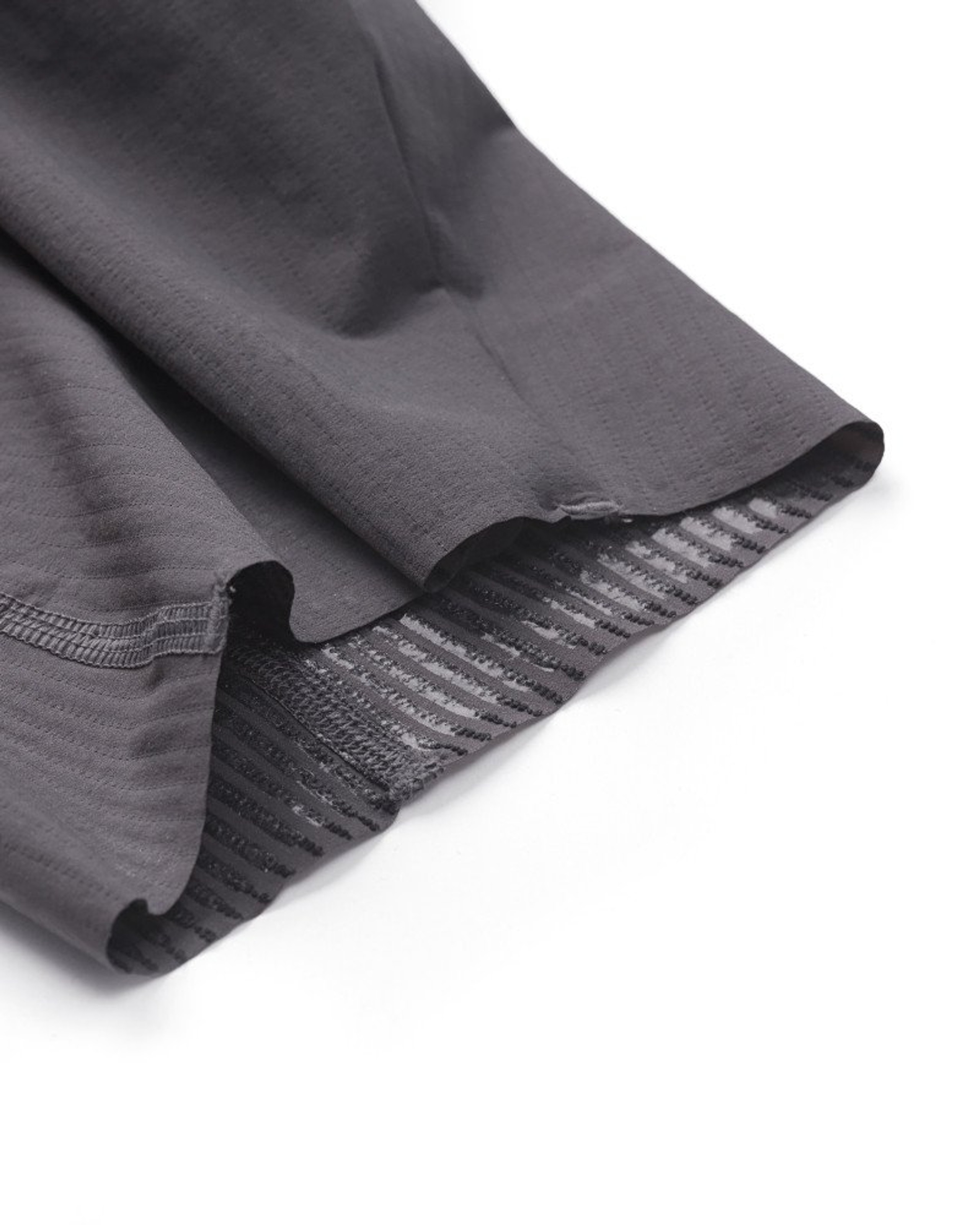 Dark Grey Solitude cycling bibs, detail view showing ribbed leg gripper and hem construction