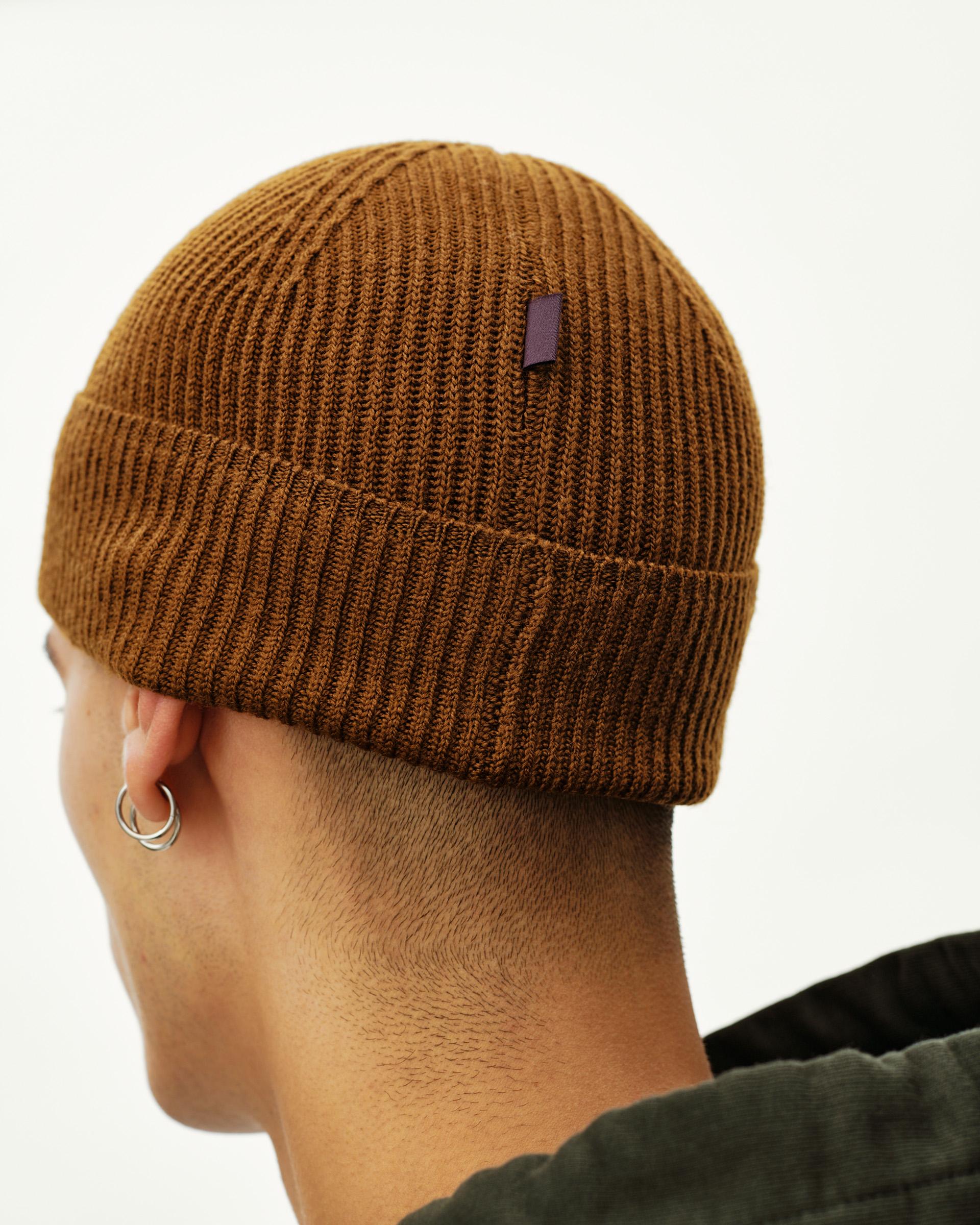 Wood brown Off-Race Merino Knit beanie, rear view on model with ribbed cuff and small woven label