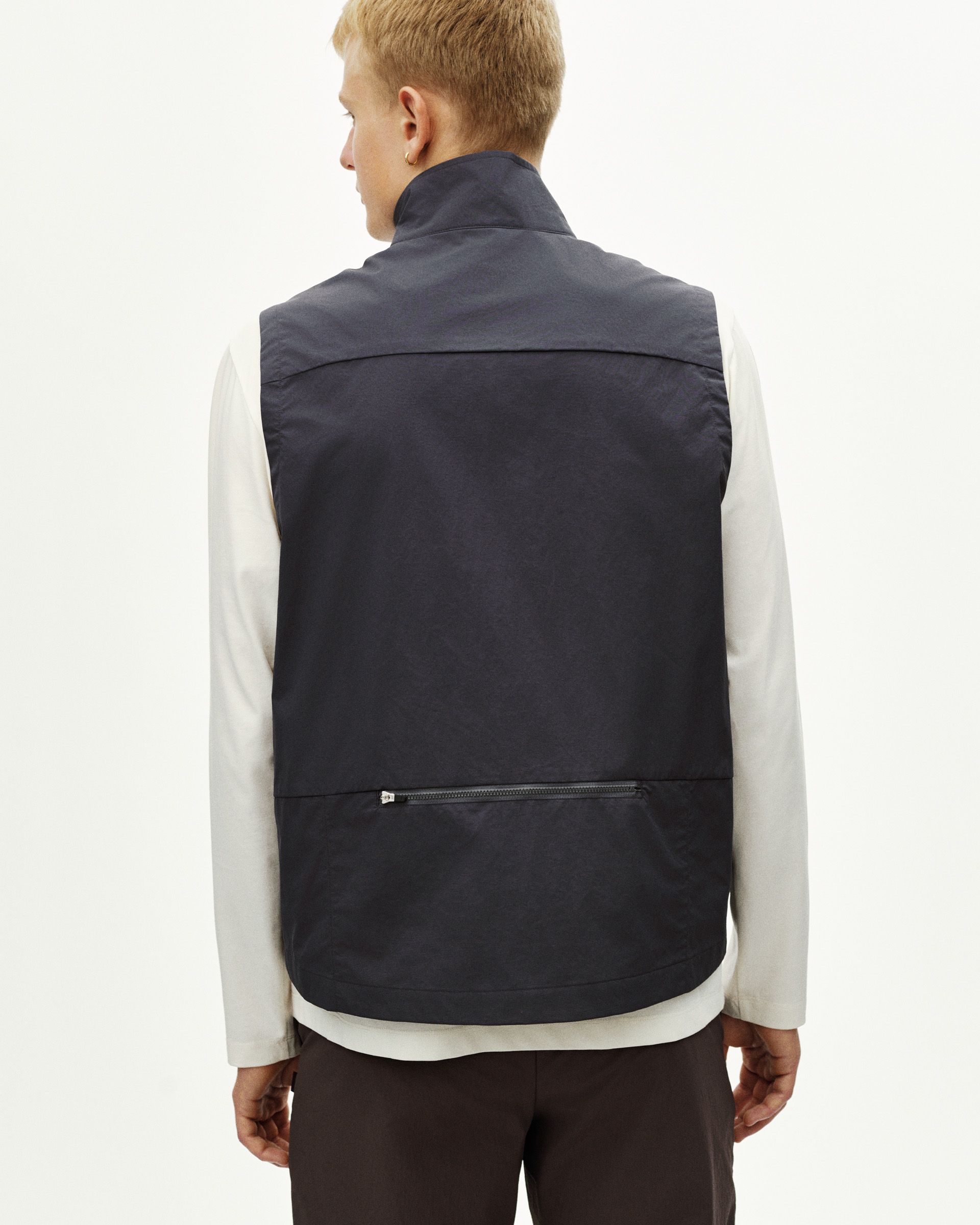 Dark Grey Off-Race Utility vest on model, rear view with horizontal zip pocket