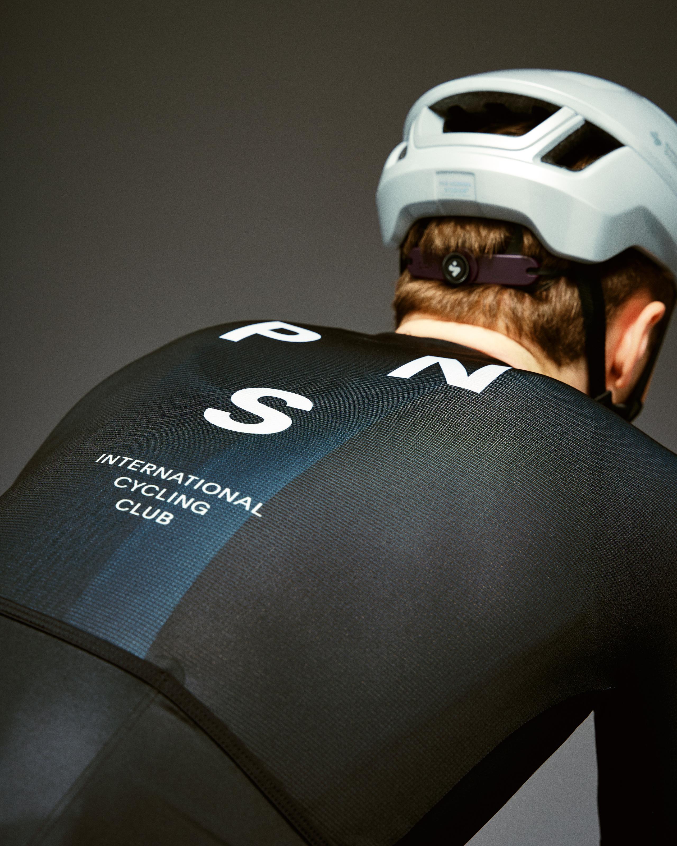 Black Mechanism cycling jersey on model, rear view with white logo and blue side panel