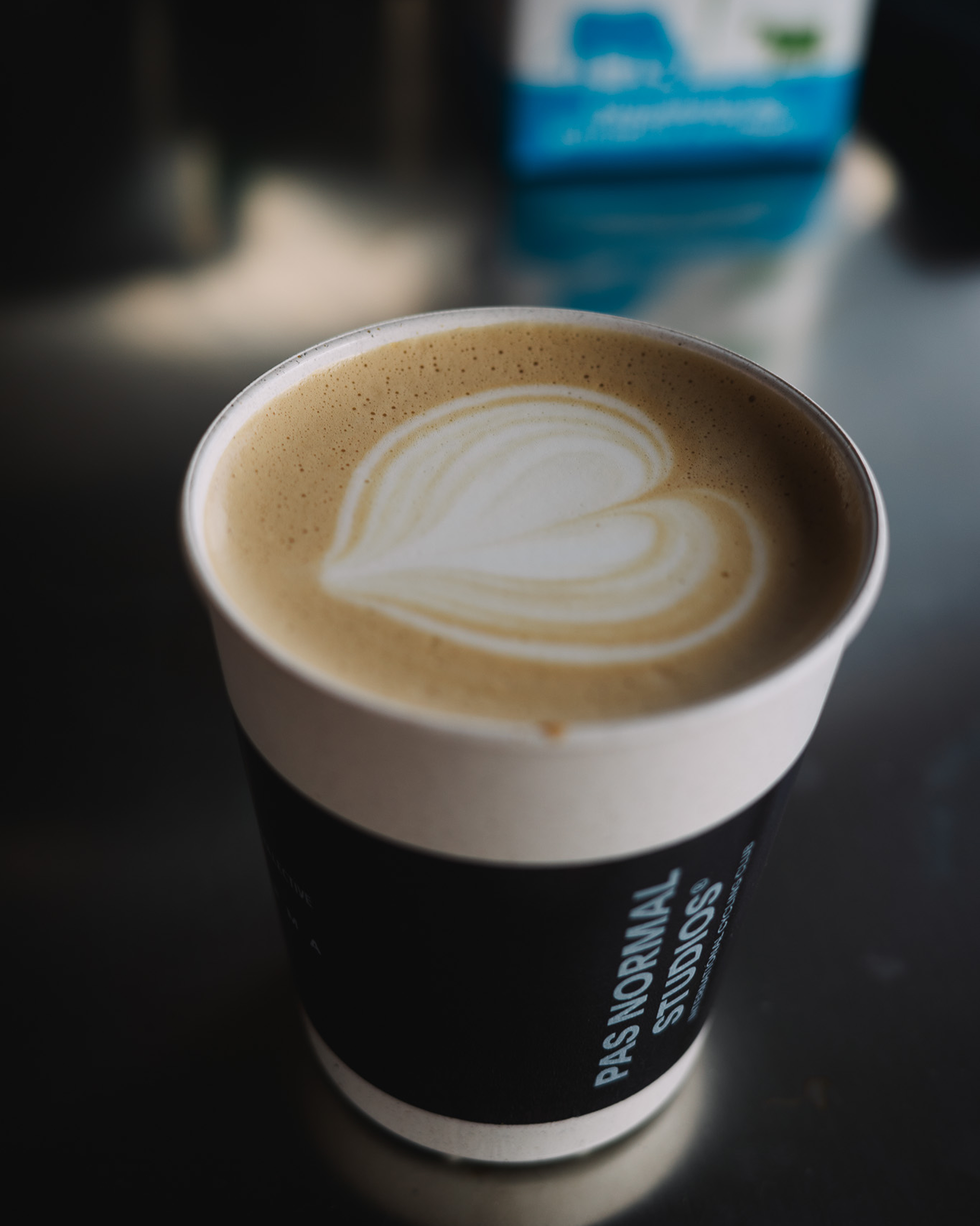 Coffee cup with latte art and branding in café setting