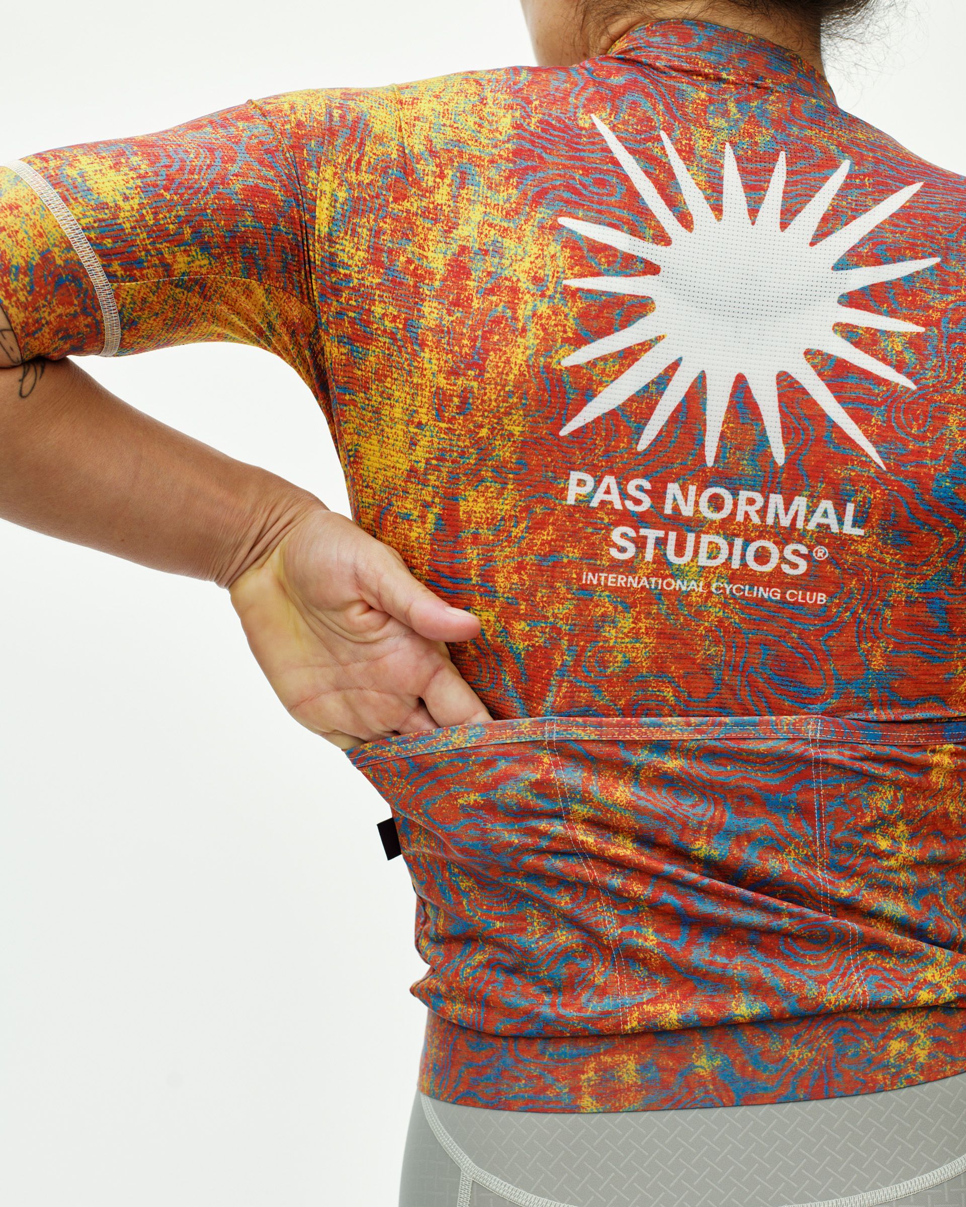 Breakfast Club Mechanism cycling jersey on model, rear view with white sun logo and marbled print