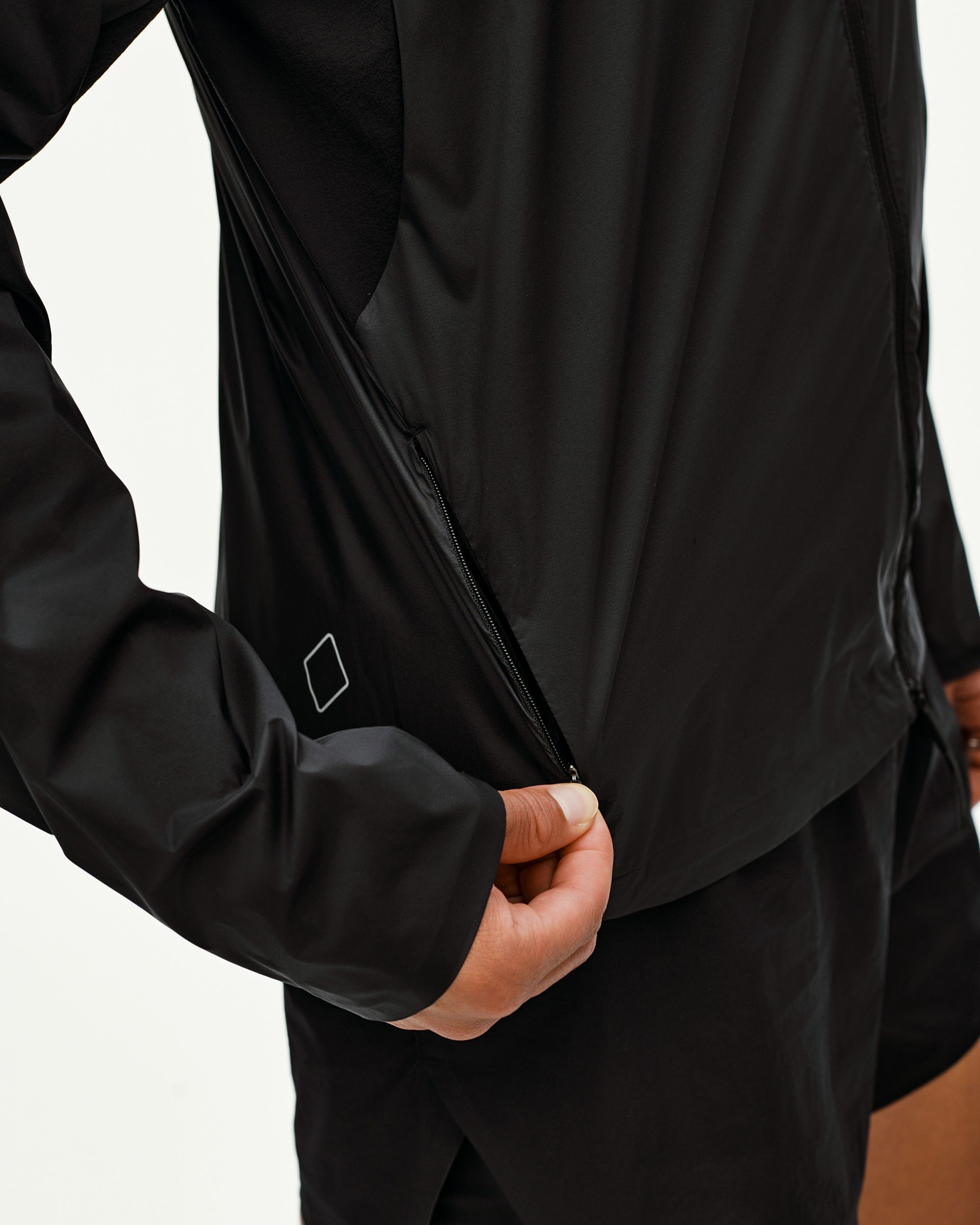 Black Balance Windproof cycling jacket, side detail on model showing open underarm zip