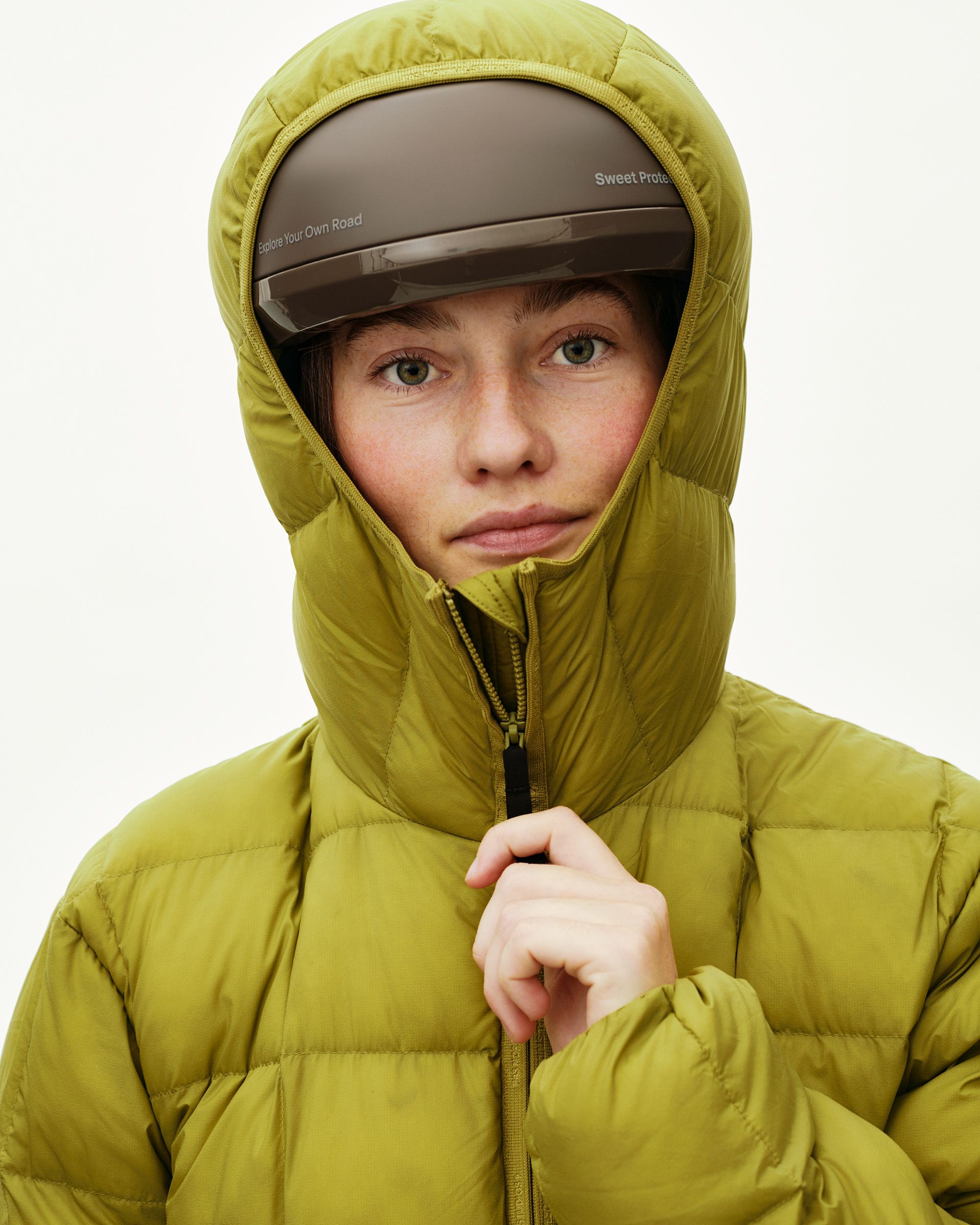 Dark Lime green Off-Race Down Liner jacket on model, front detail with hood up and cycling helmet worn over