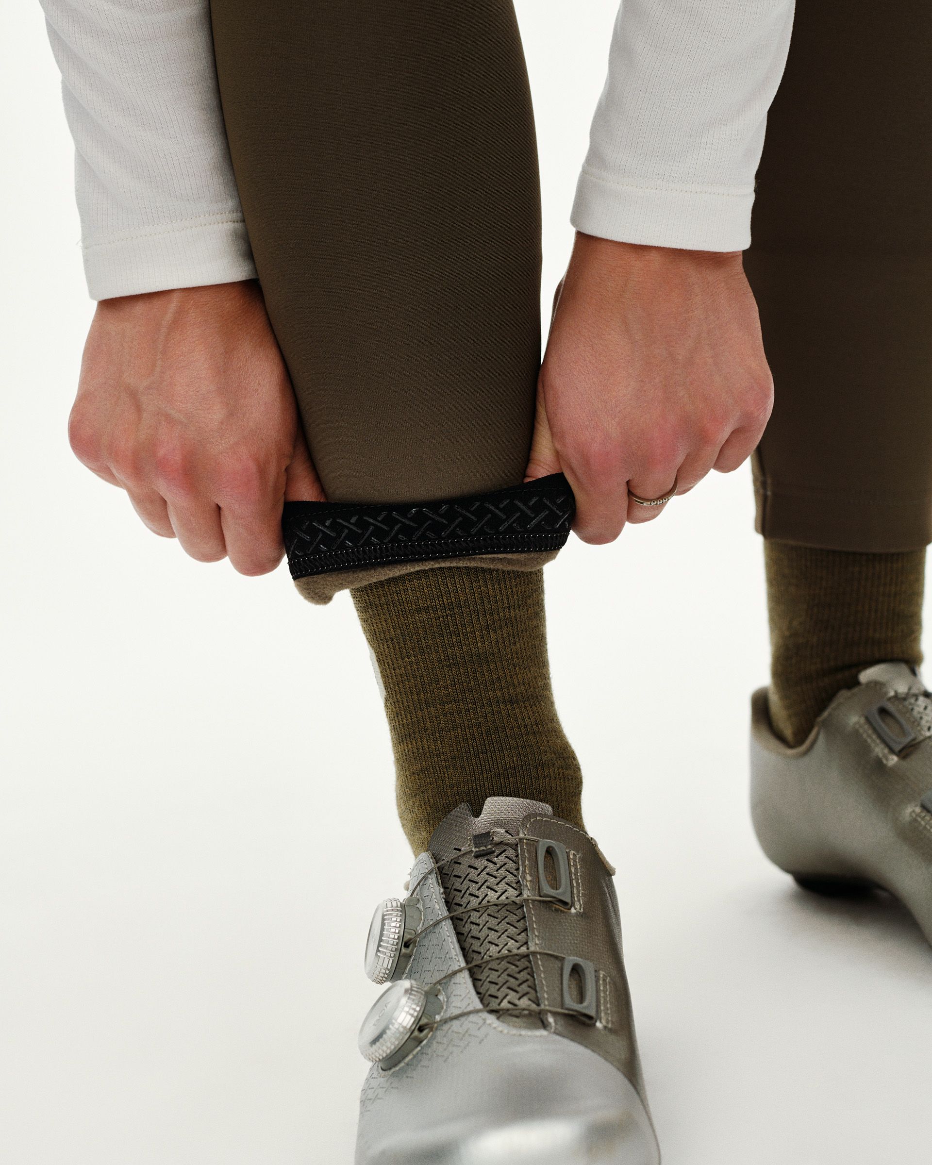 Dark Earth brown PAS Mechanism Thermal Long cycling bibs, ankle detail on model showing textured gripper cuff