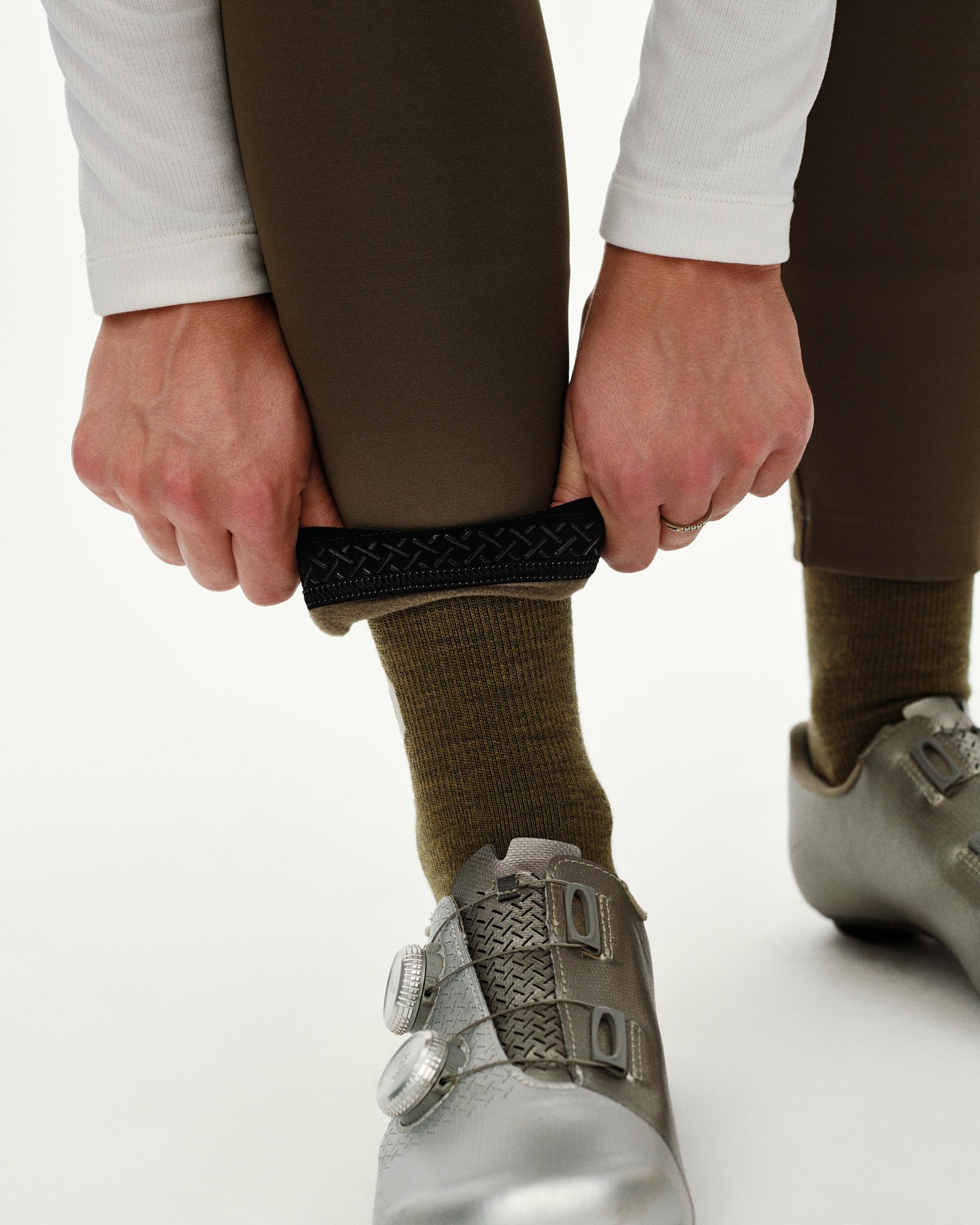 Dark Earth brown PAS Mechanism Thermal Long cycling bibs, ankle detail on model showing textured gripper cuff