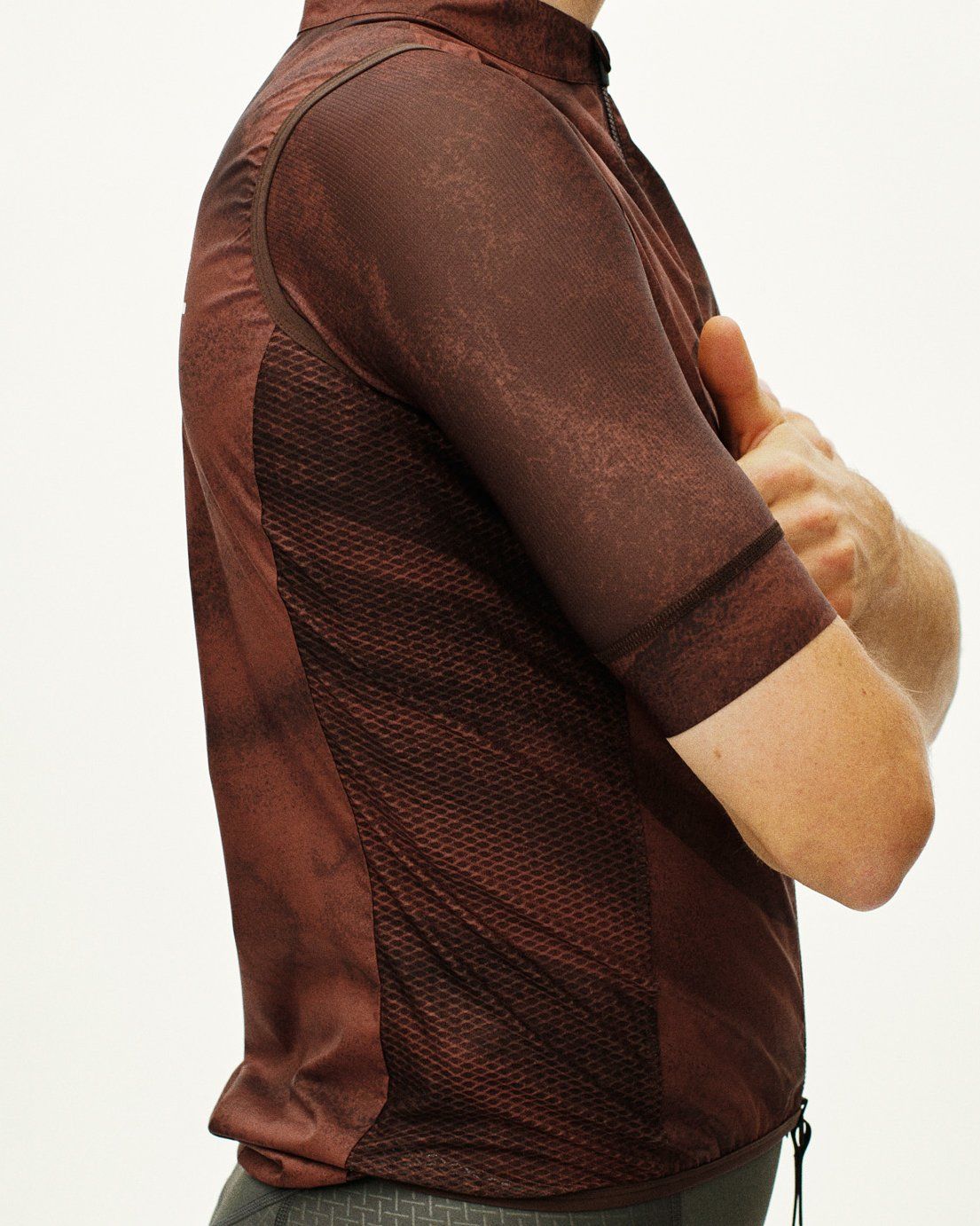 Brown Mechanism Stow Away cycling vest, side view on model with mesh side panels