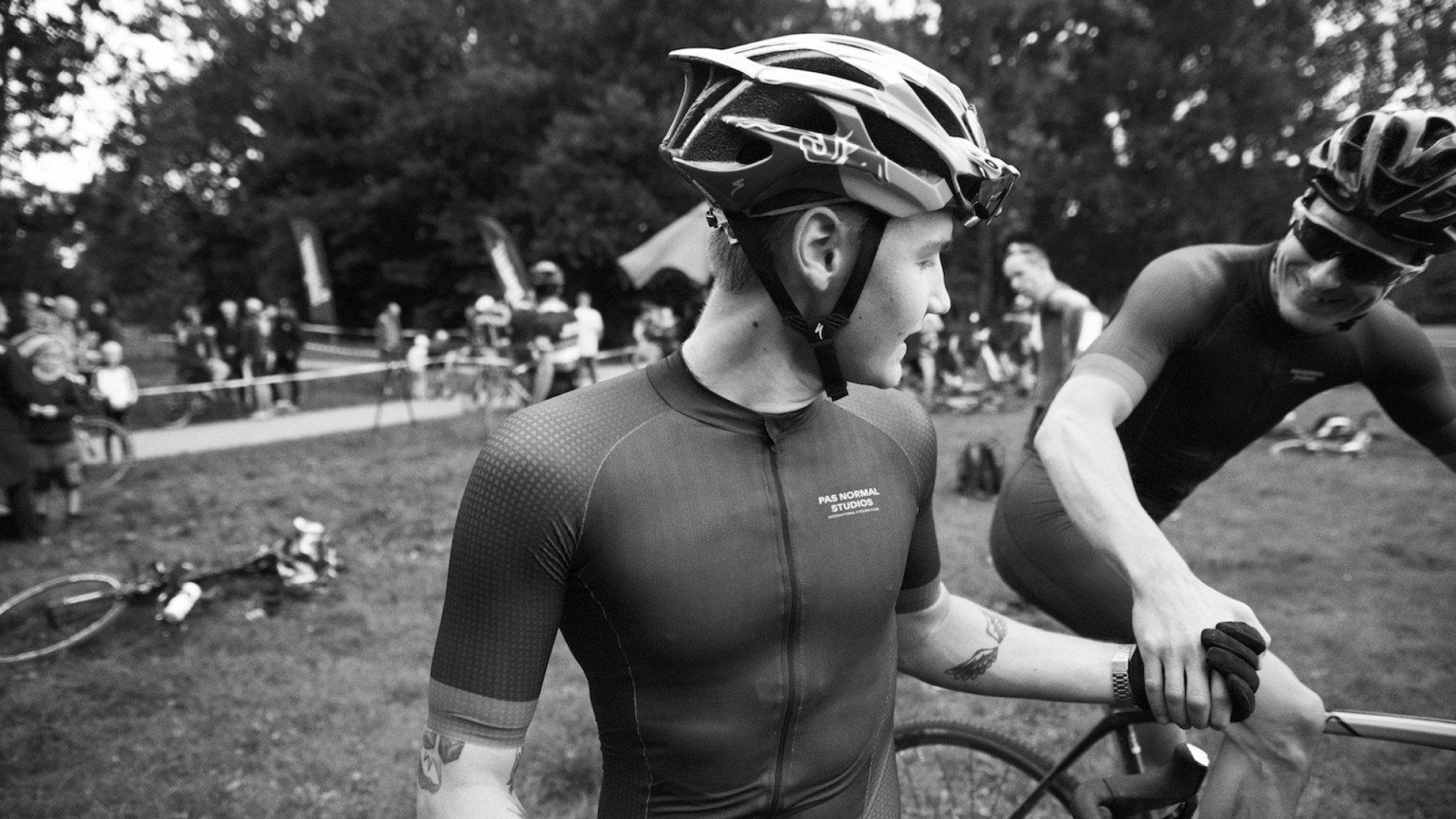Model wearing dark textured cycling jersey with chest branding at cyclocross race