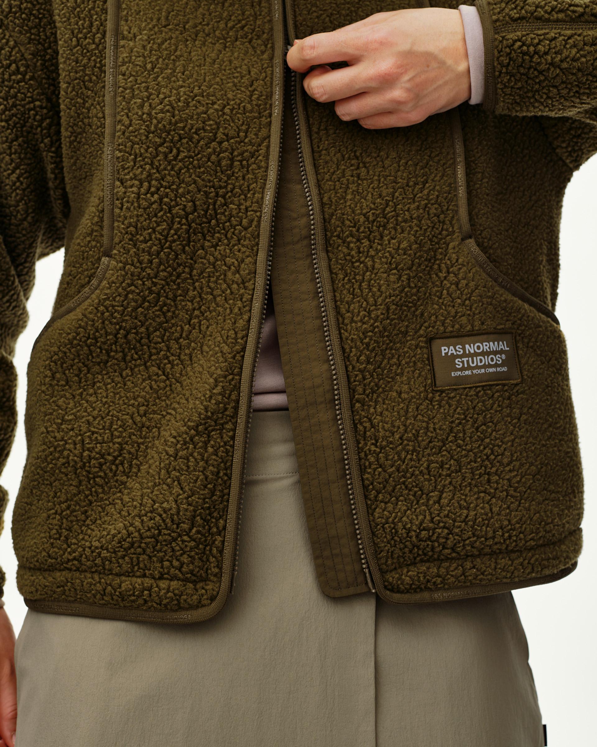 Deep Olive Off-Race Pile Fleece jacket, front detail on model opened with branded patch pocket