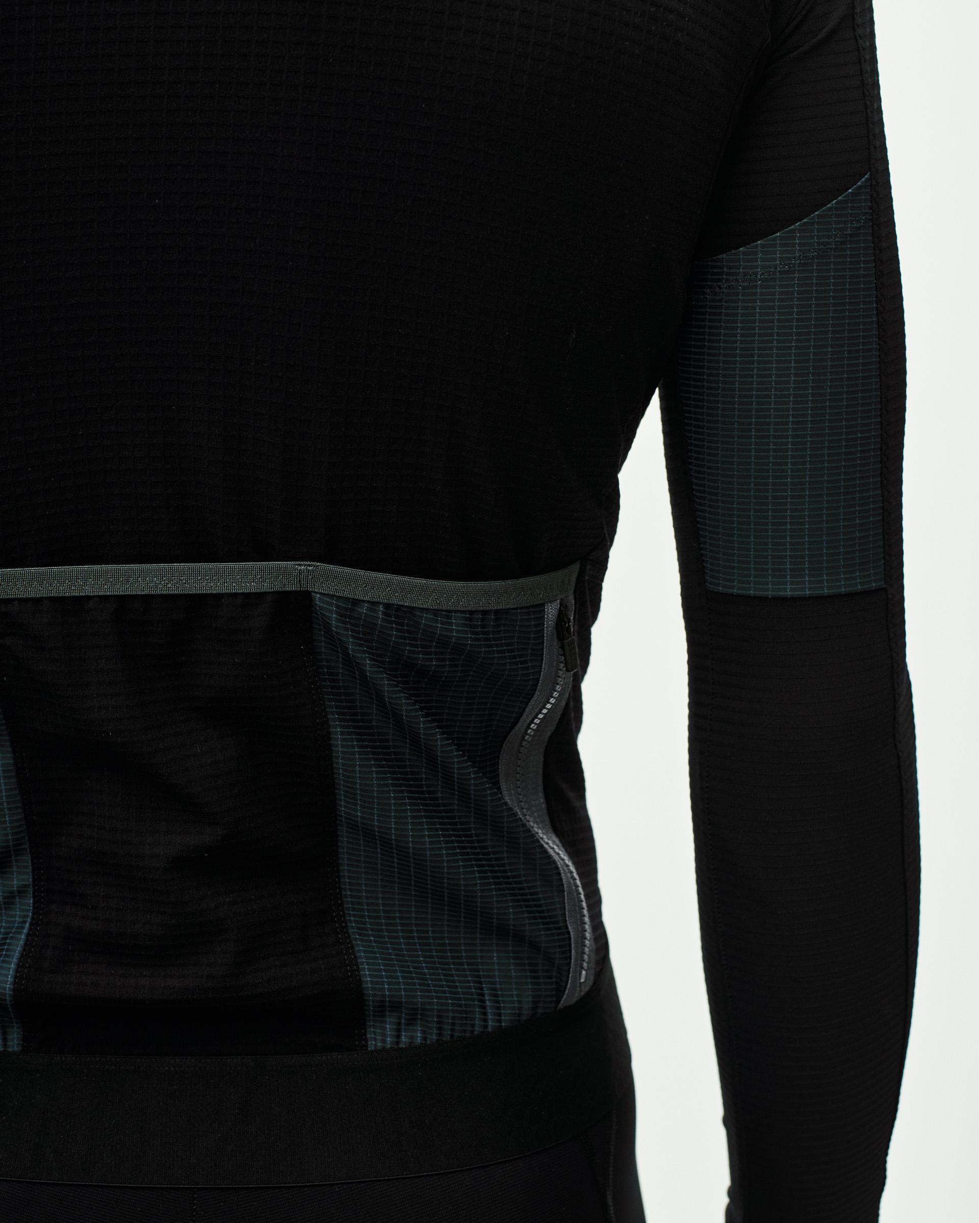 Black Escapism long sleeve cycling jersey, side detail view with contrast grid panel and zip pocket