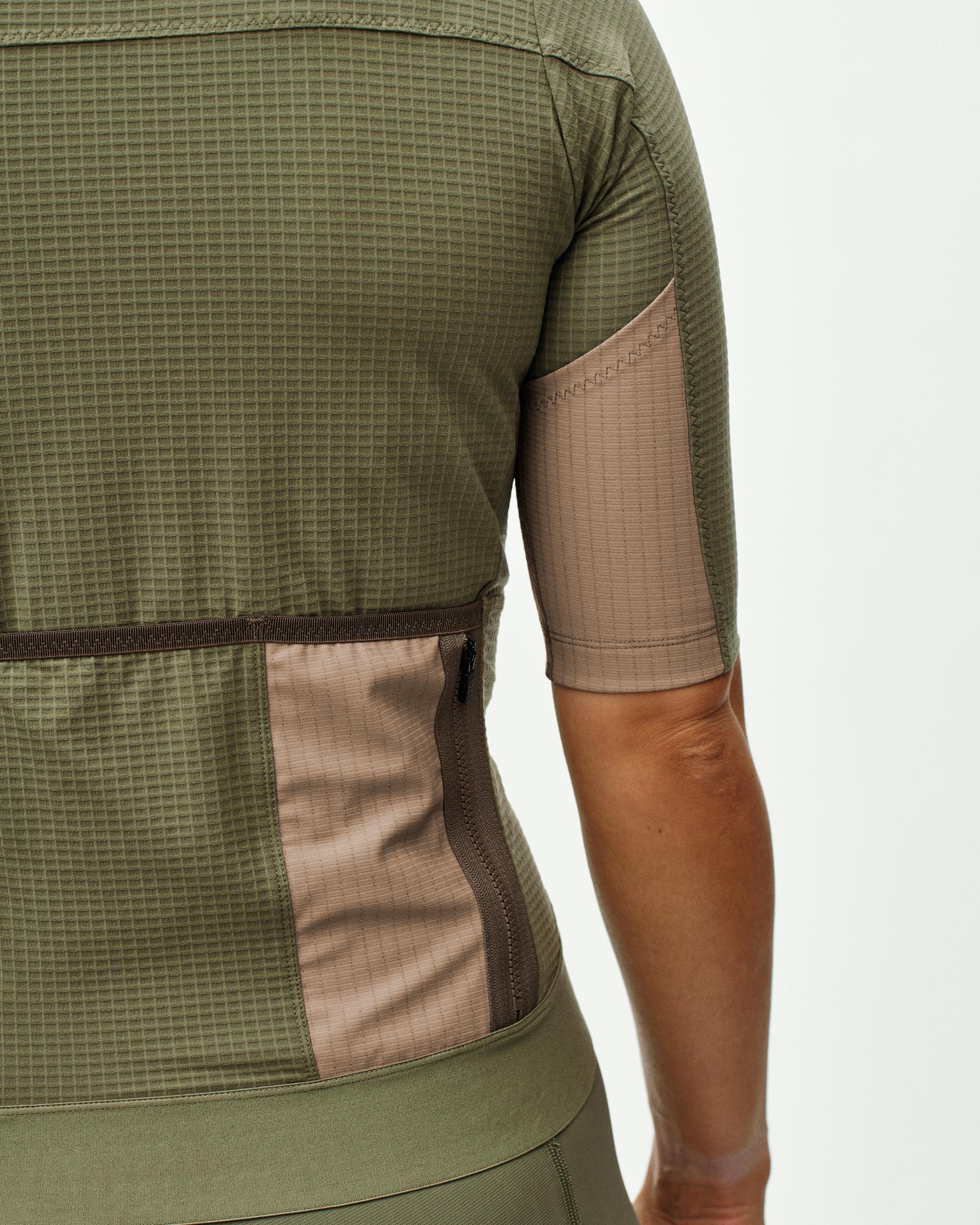 Light Olive Escapism cycling jersey on model showing rear cargo pockets with mesh panels
