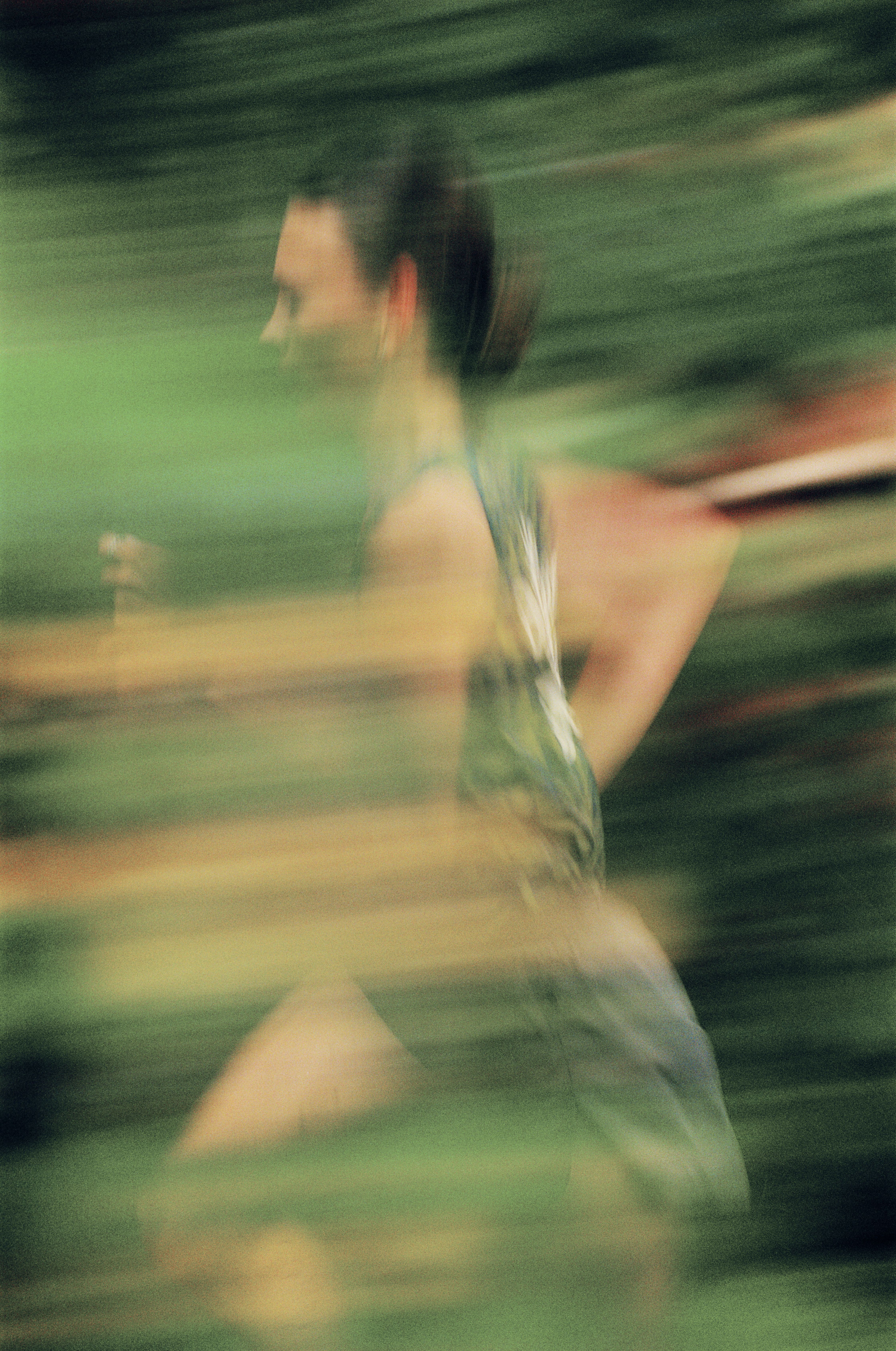Blurred motion shot of cyclist in light colored kit running on track