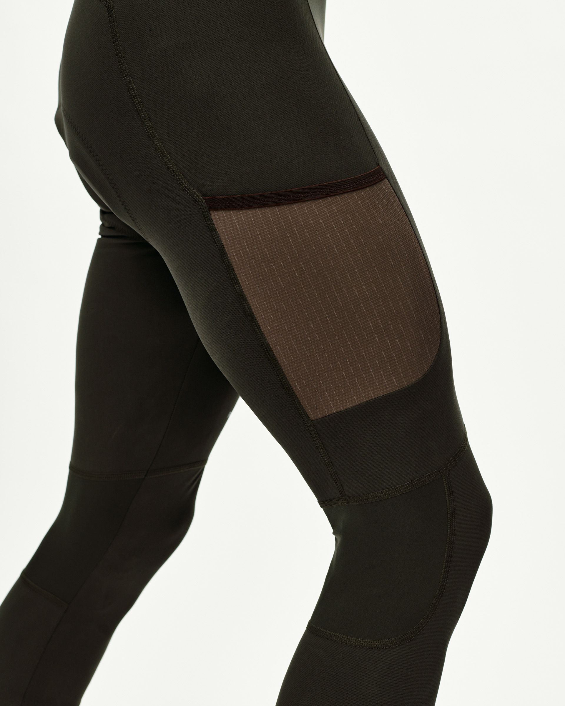 Dark Olive Escapism Long Cargo cycling bibs, side detail on model with ripstop thigh panel