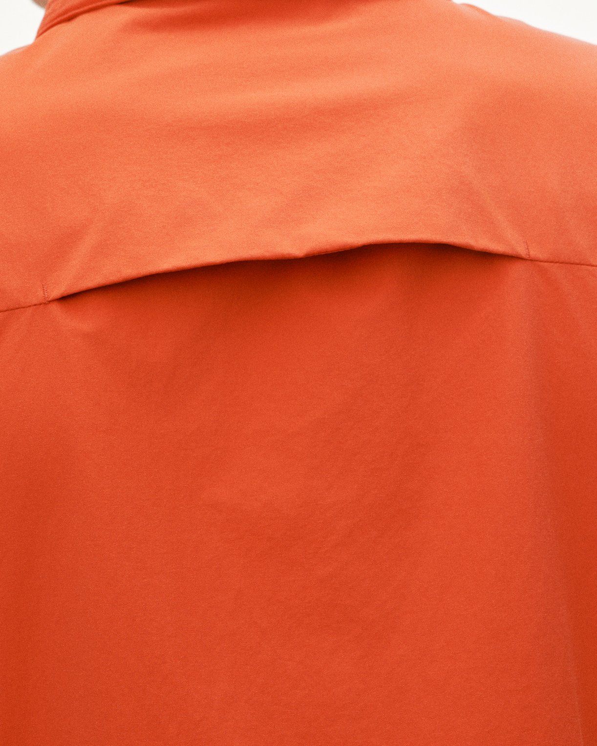 Orange Off-Race Utility jacket, detail view showing shoulder seam and fabric texture