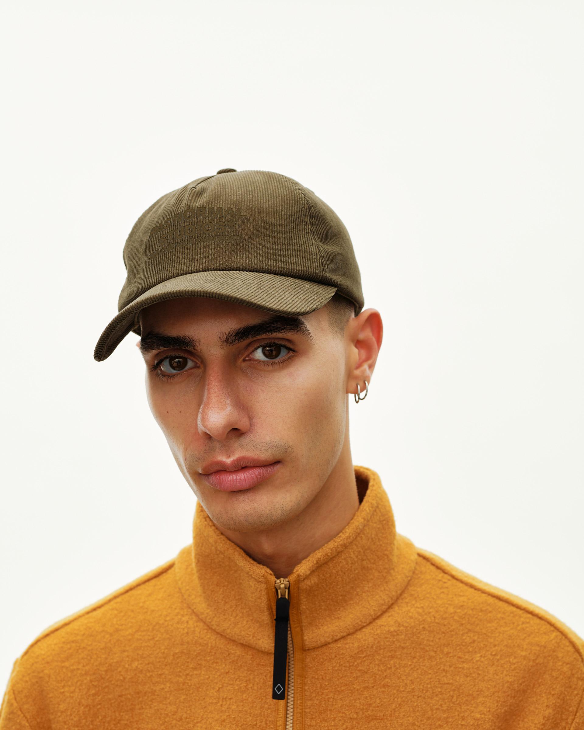 Deep Olive Off-Race Tech Corduroy cap on model, front view with tonal embroidered logo on crown