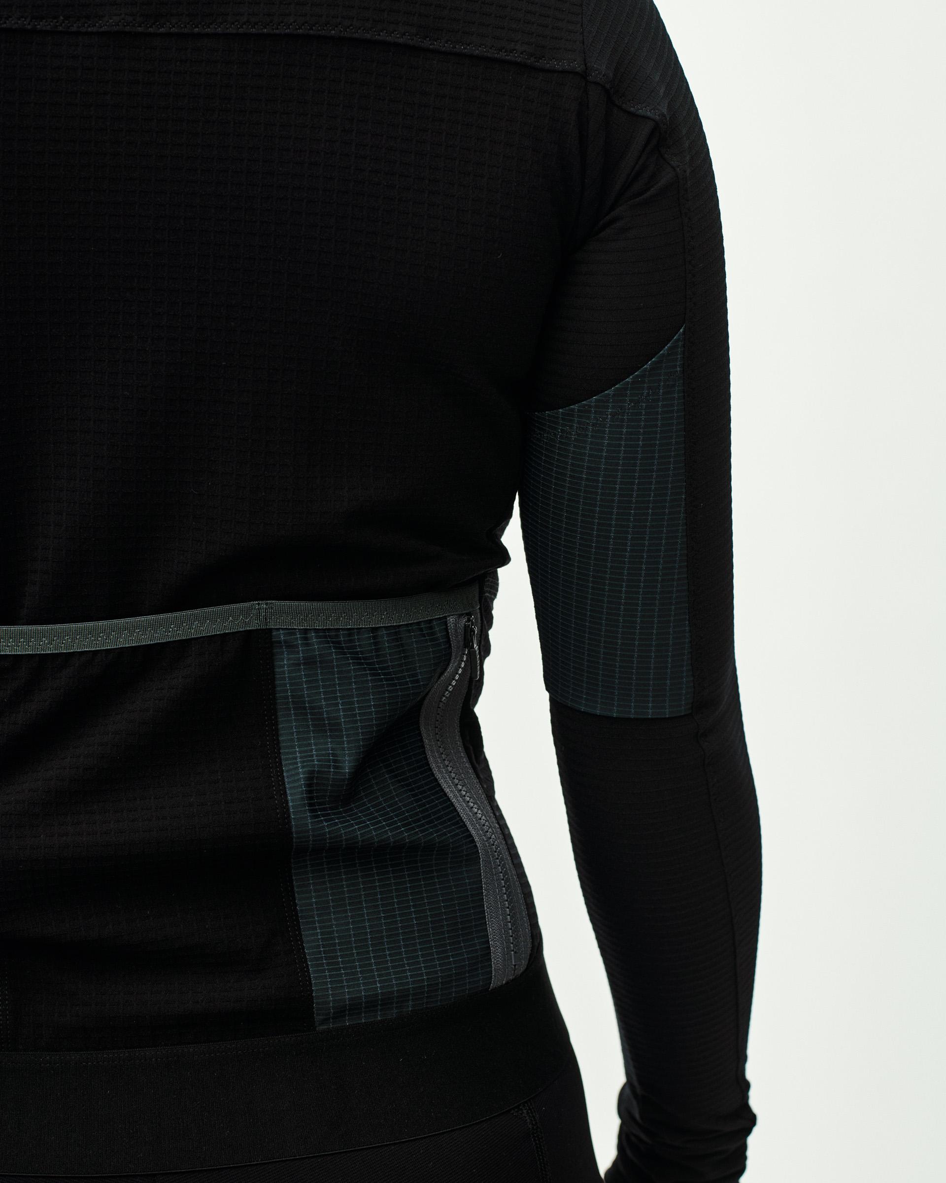 Black Escapism long sleeve cycling jersey on model with teal grid panel detail