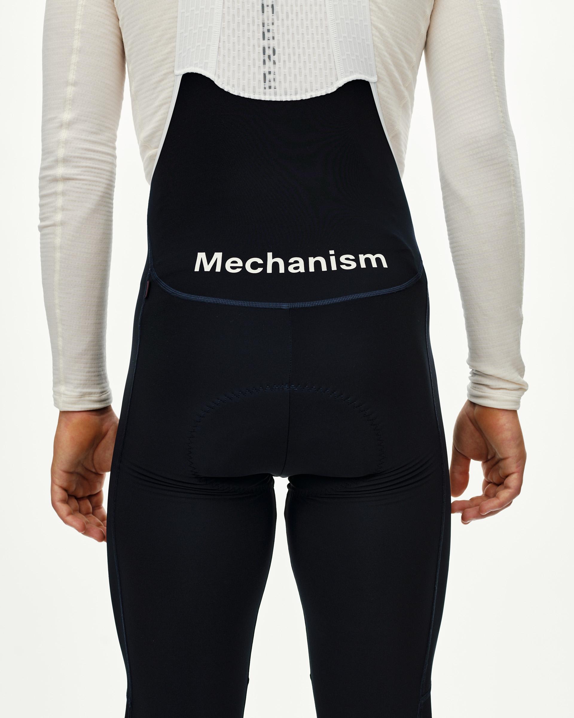 Navy Mechanism cycling long bibs on model, rear view with white logo print and back pocket