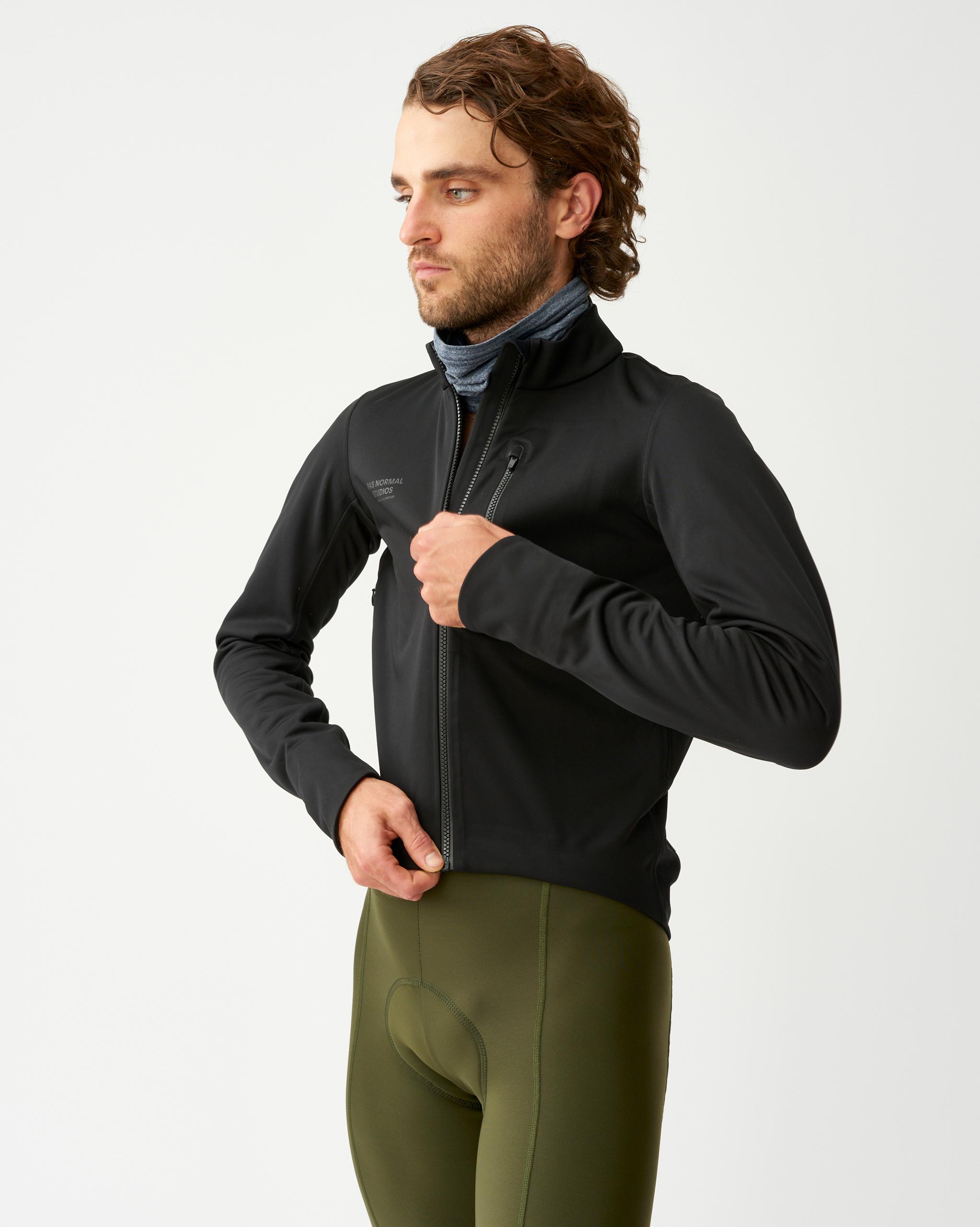 Black Essential Thermal cycling jacket on model, three-quarter front view with full zip and chest zip pocket